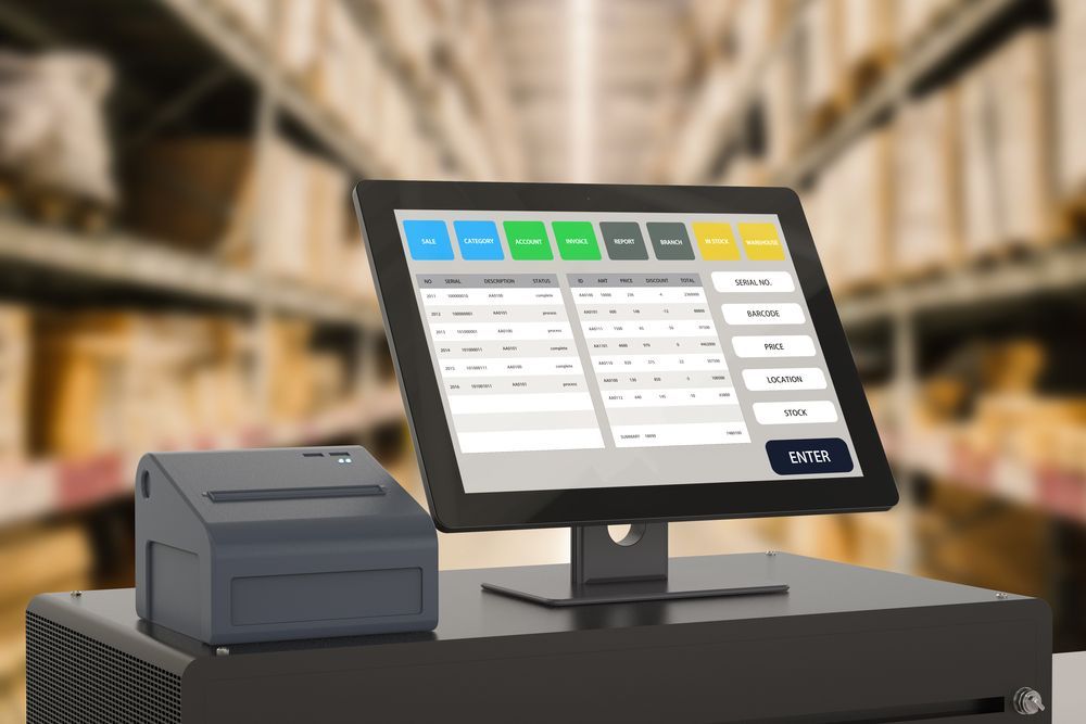 A computer monitor is sitting on top of a desk in a warehouse.