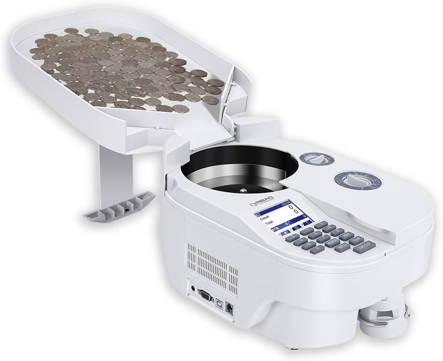 Maquina contadora de monedas de color blanco, con monedas en la bandeja superior, clasificando y contando.