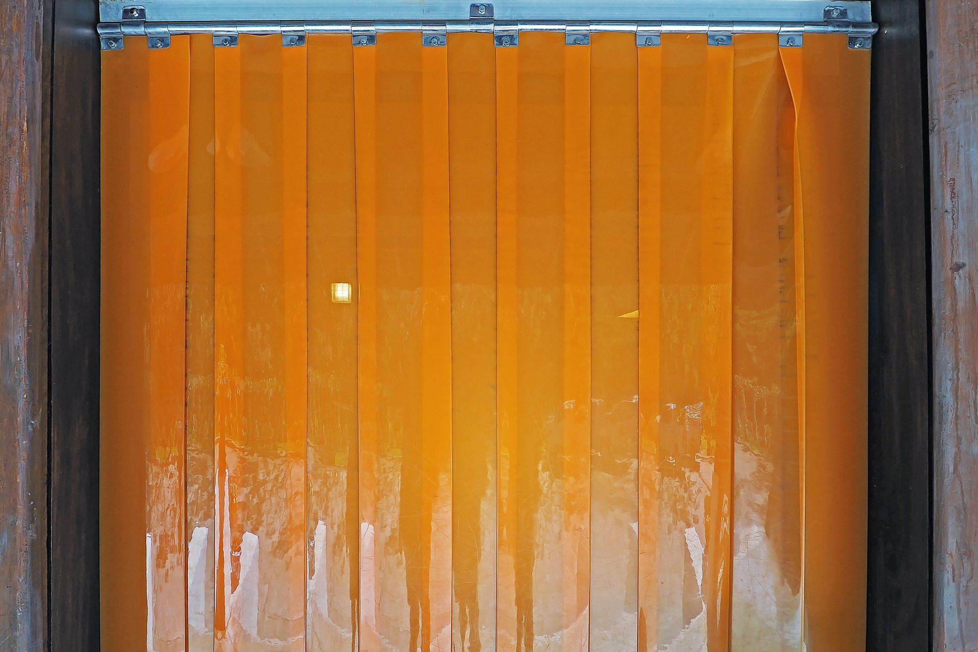 A close up of an orange curtain on a door.