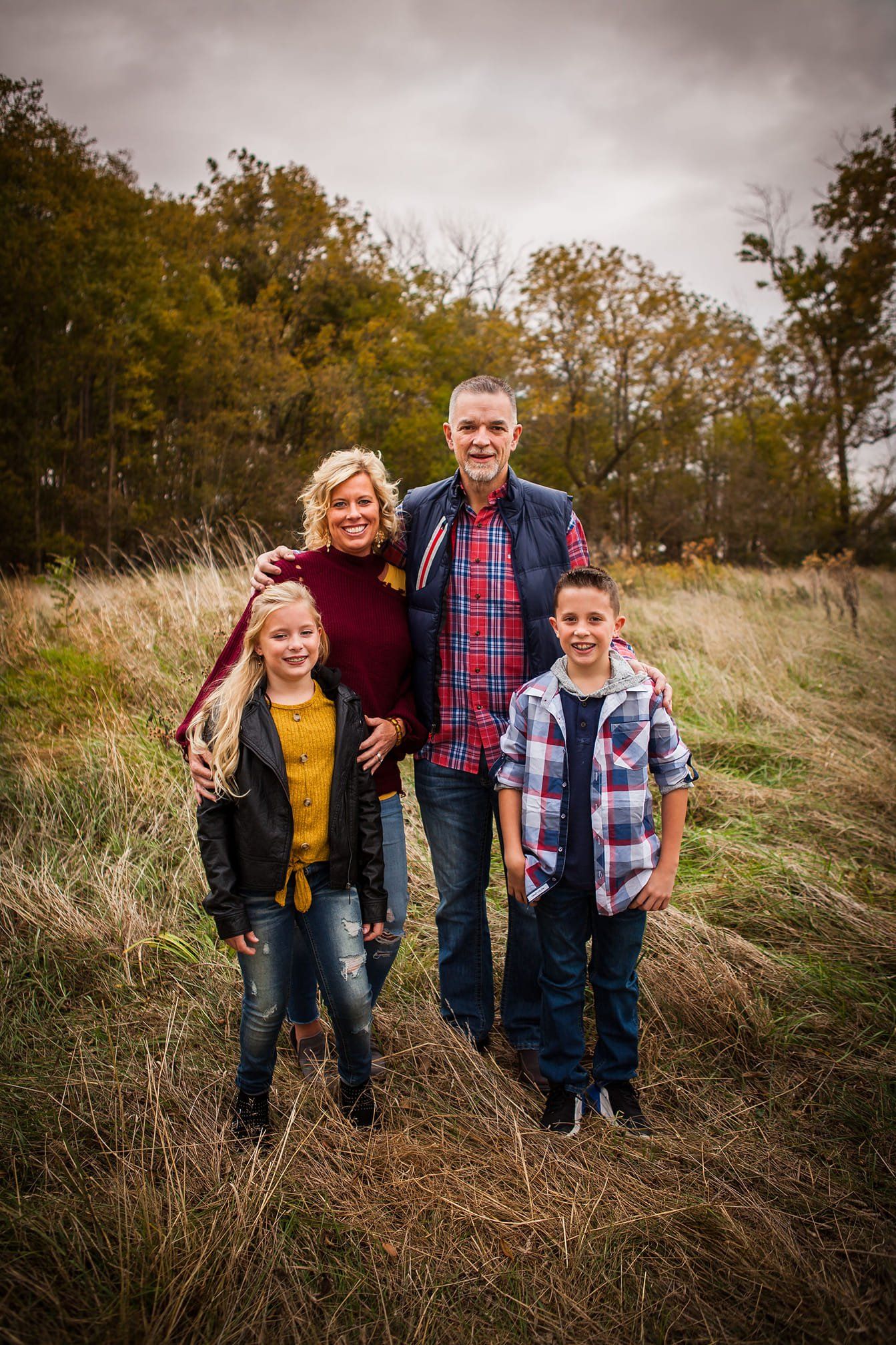 A family is posing for a picture in a field.