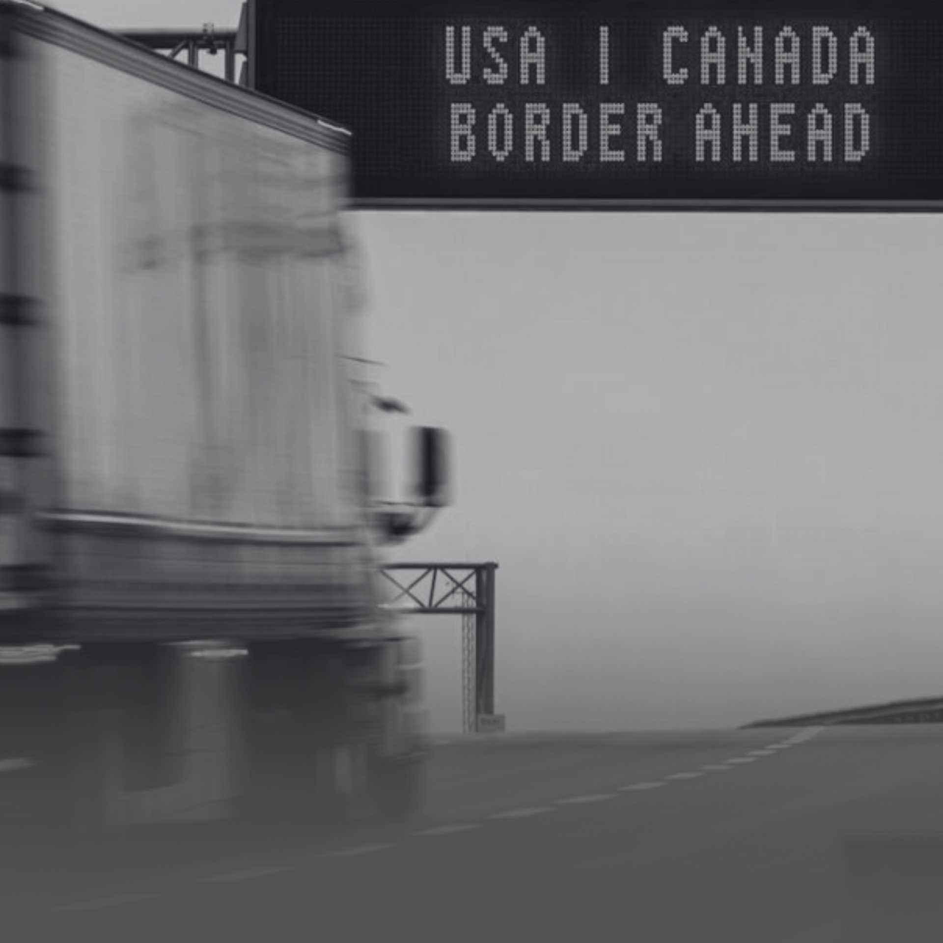 Truck near USA-Canada border sign, highlighting Non-Occupational Accident for B-1 Visa Truckers.