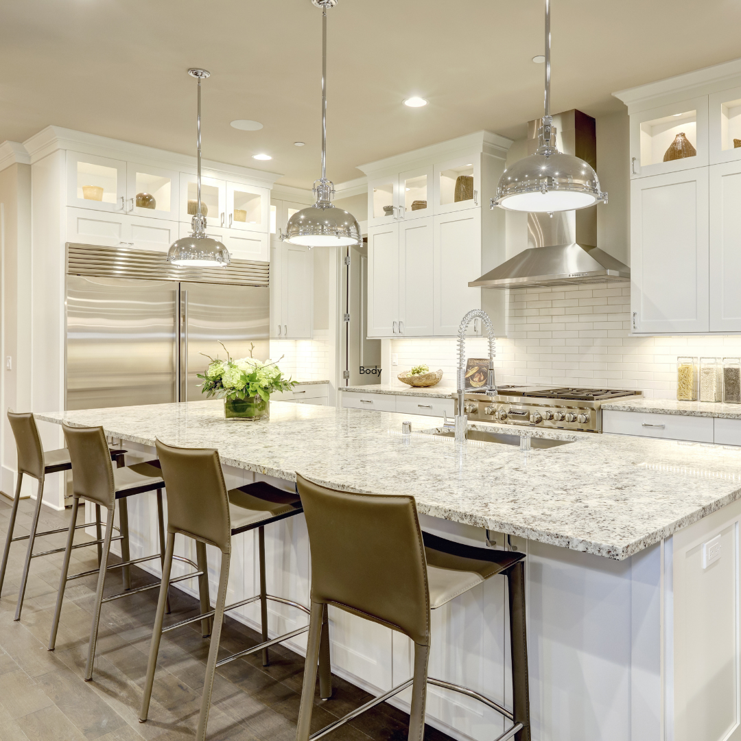 A kitchen with white cabinets , granite counter tops , stainless steel appliances and a large island.