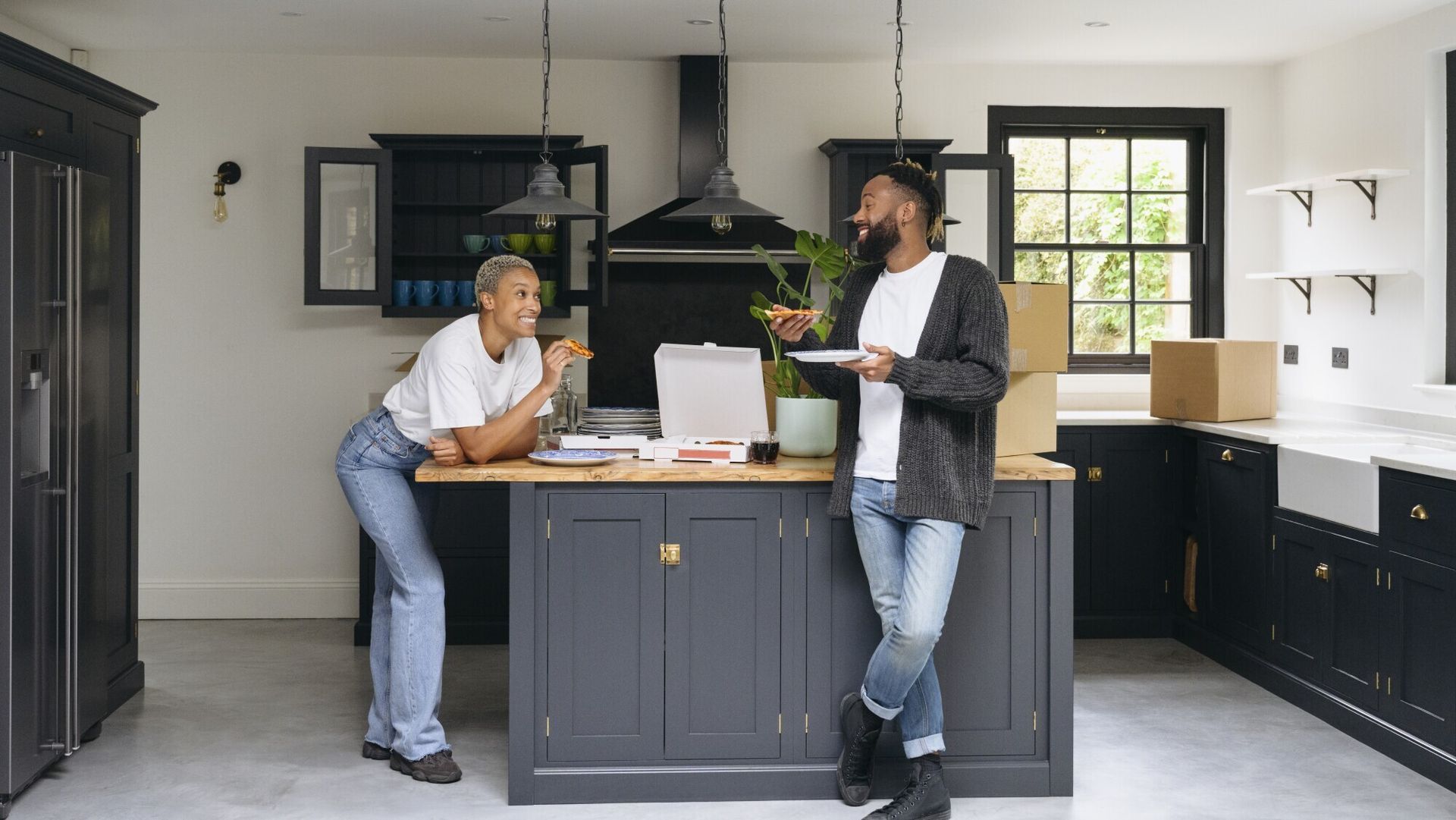 A man and a woman are standing next to each other in a kitchen.