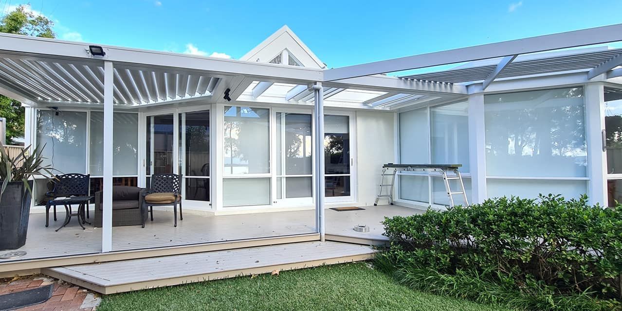 A White House With a Patio and a Pergola in the Backyard — JAX Painting Services in Central Coast, NSW