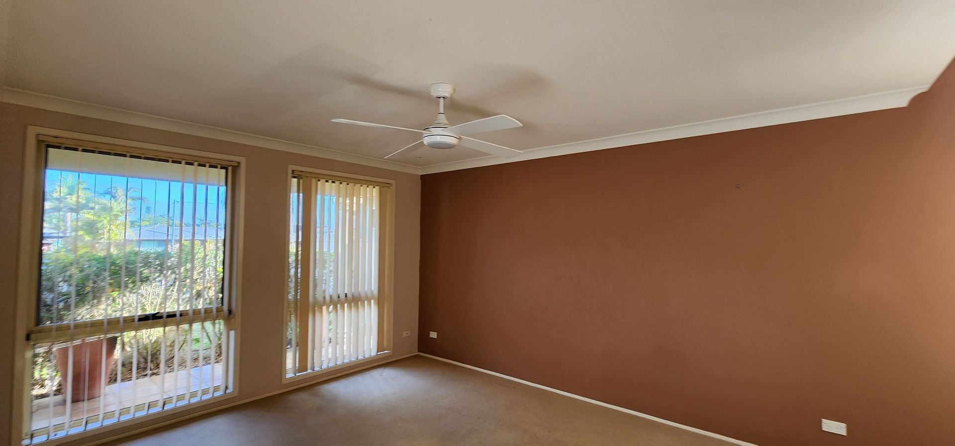 An Empty Living Room With Brown Walls and a Ceiling Fan — JAX Painting Services in Central Coast, NSW