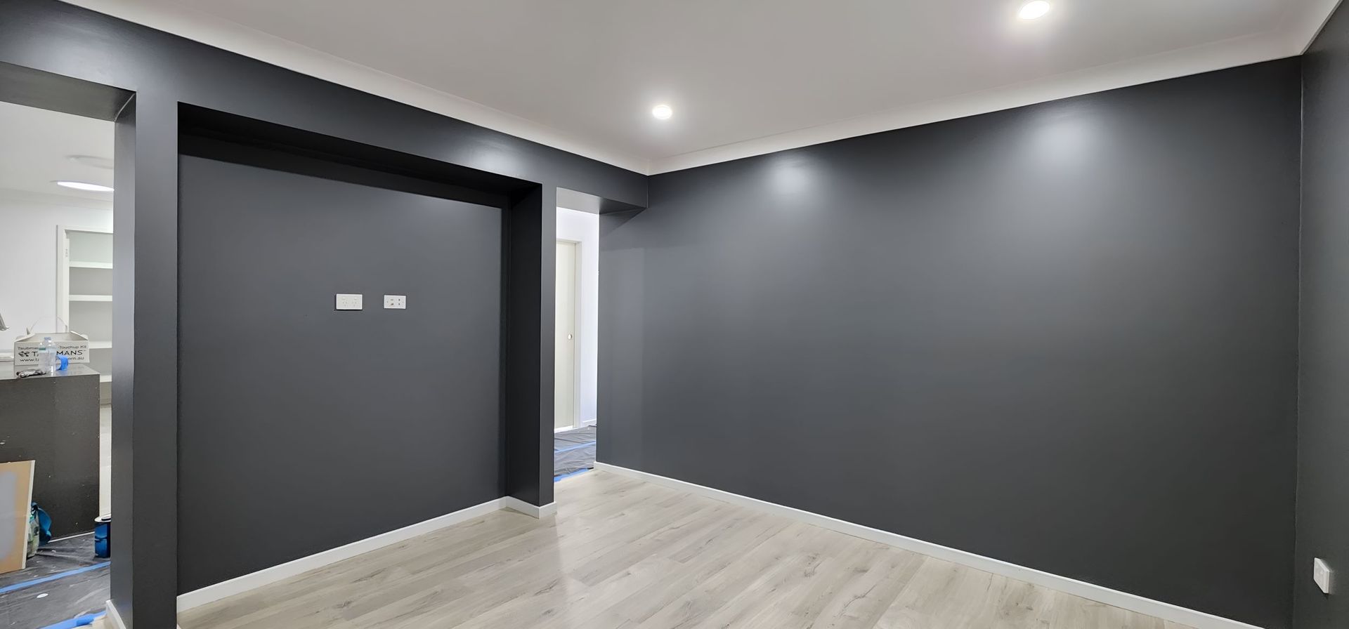 An Room With Black Walls and a Wooden Floor — JAX Painting Services in Central Coast, NSW