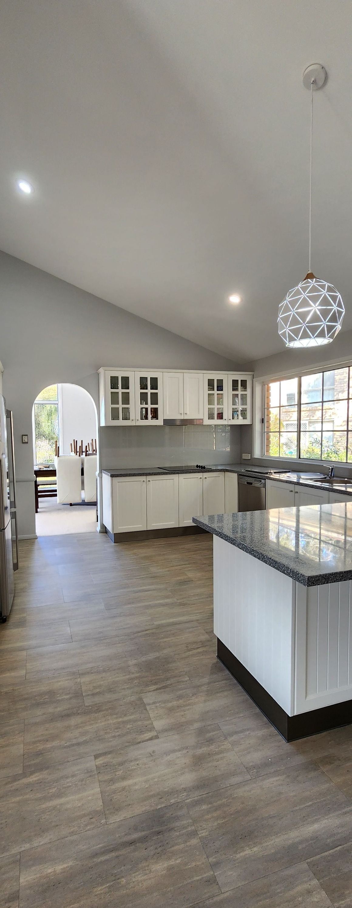 A Kitchen With White Cabinets, Granite Counter Tops, and Stainless Steel Appliances — JAX Painting Services in Central Coast, NSW