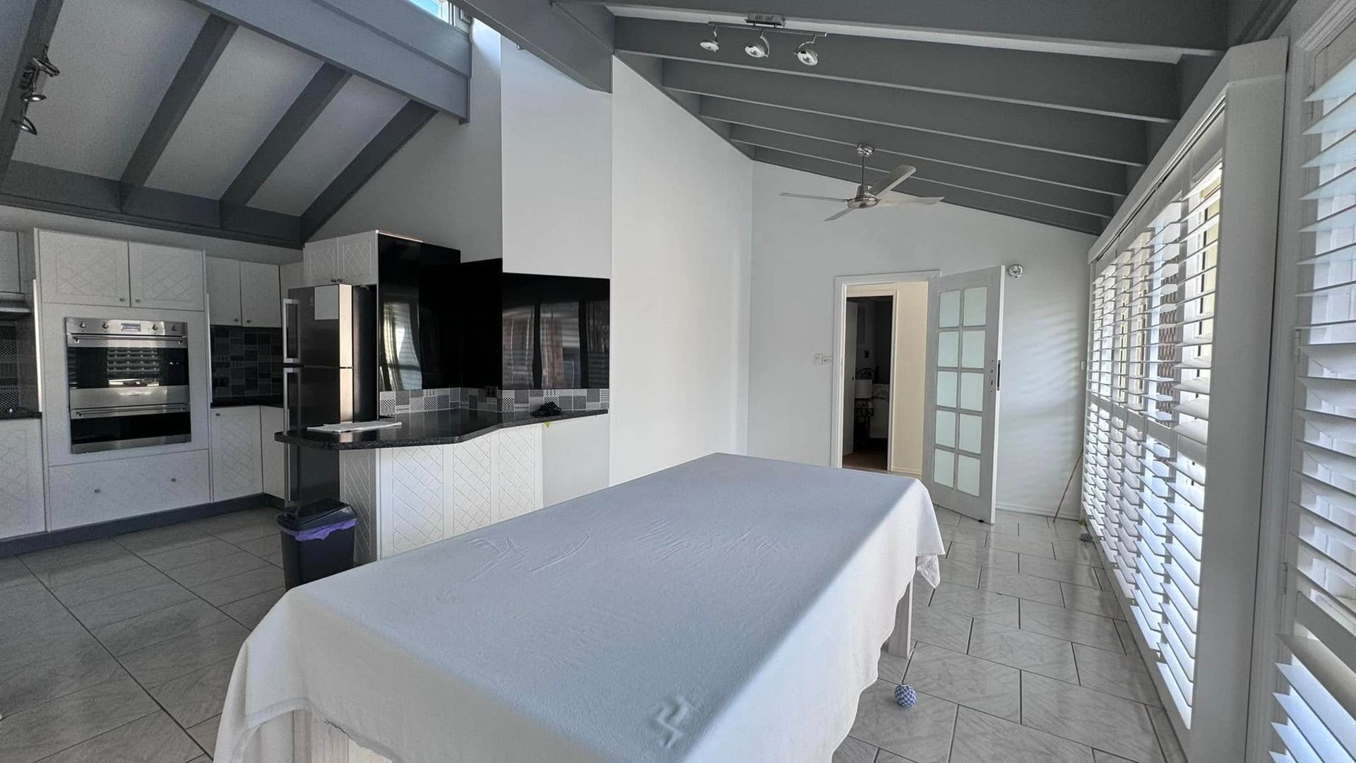 A Large Room With a Table and Shutters on the Windows — JAX Painting Services in Central Coast, NSW