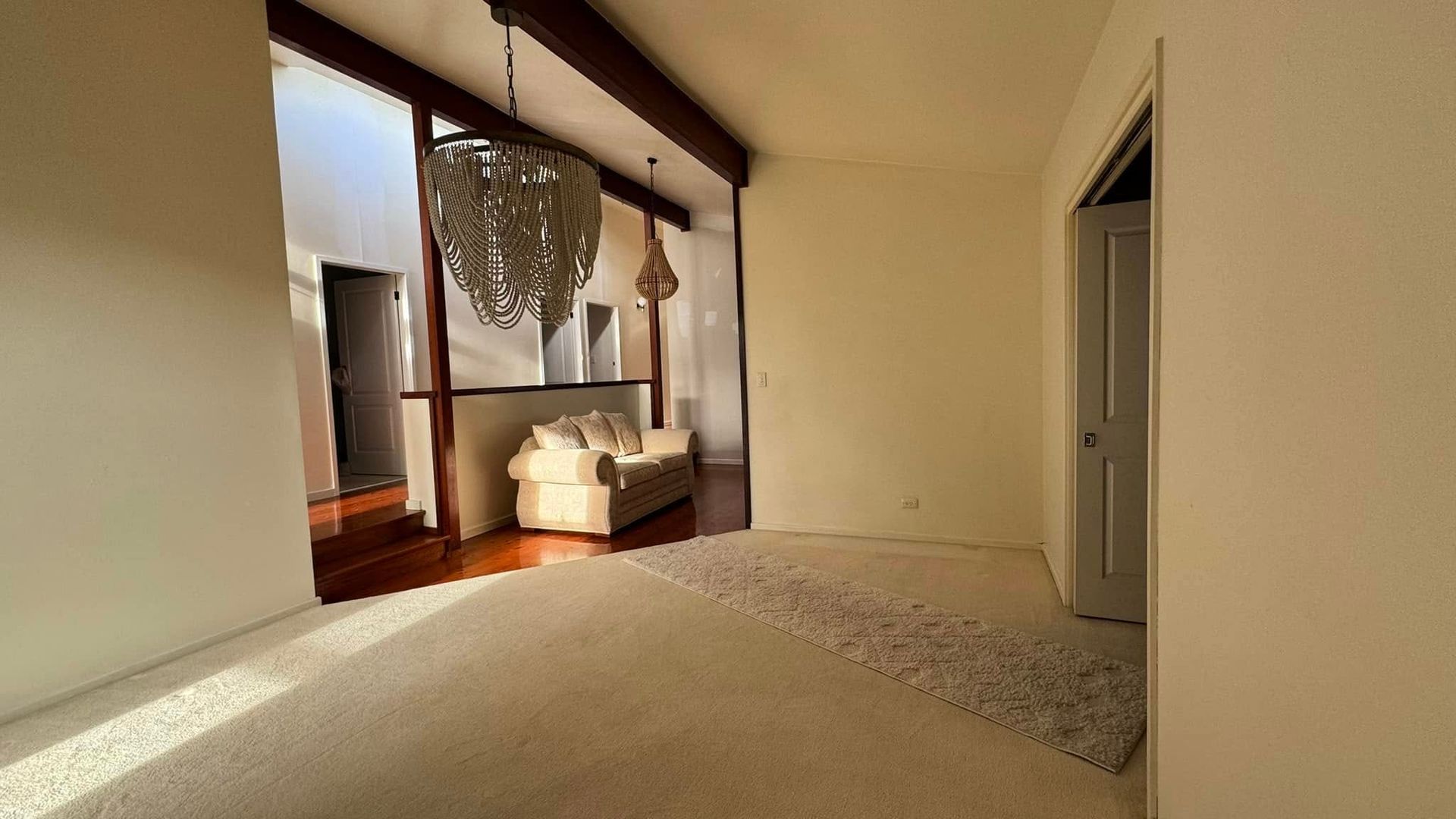 An Empty Living Room With a Couch and a Chandelier — JAX Painting Services in Central Coast, NSW