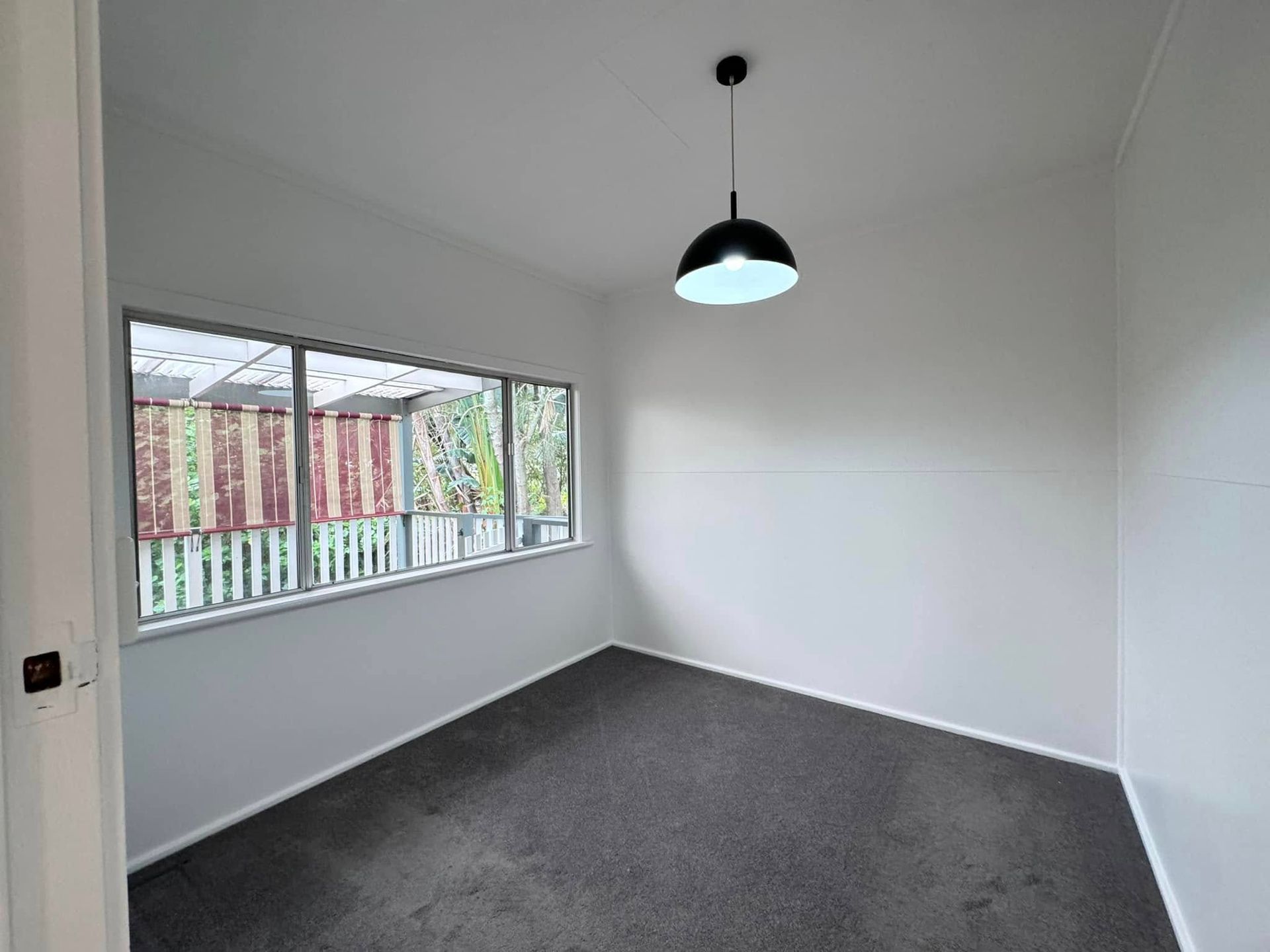 An Empty Room With a Large Window and a Pendant Light — JAX Painting Services in Central Coast, NSW