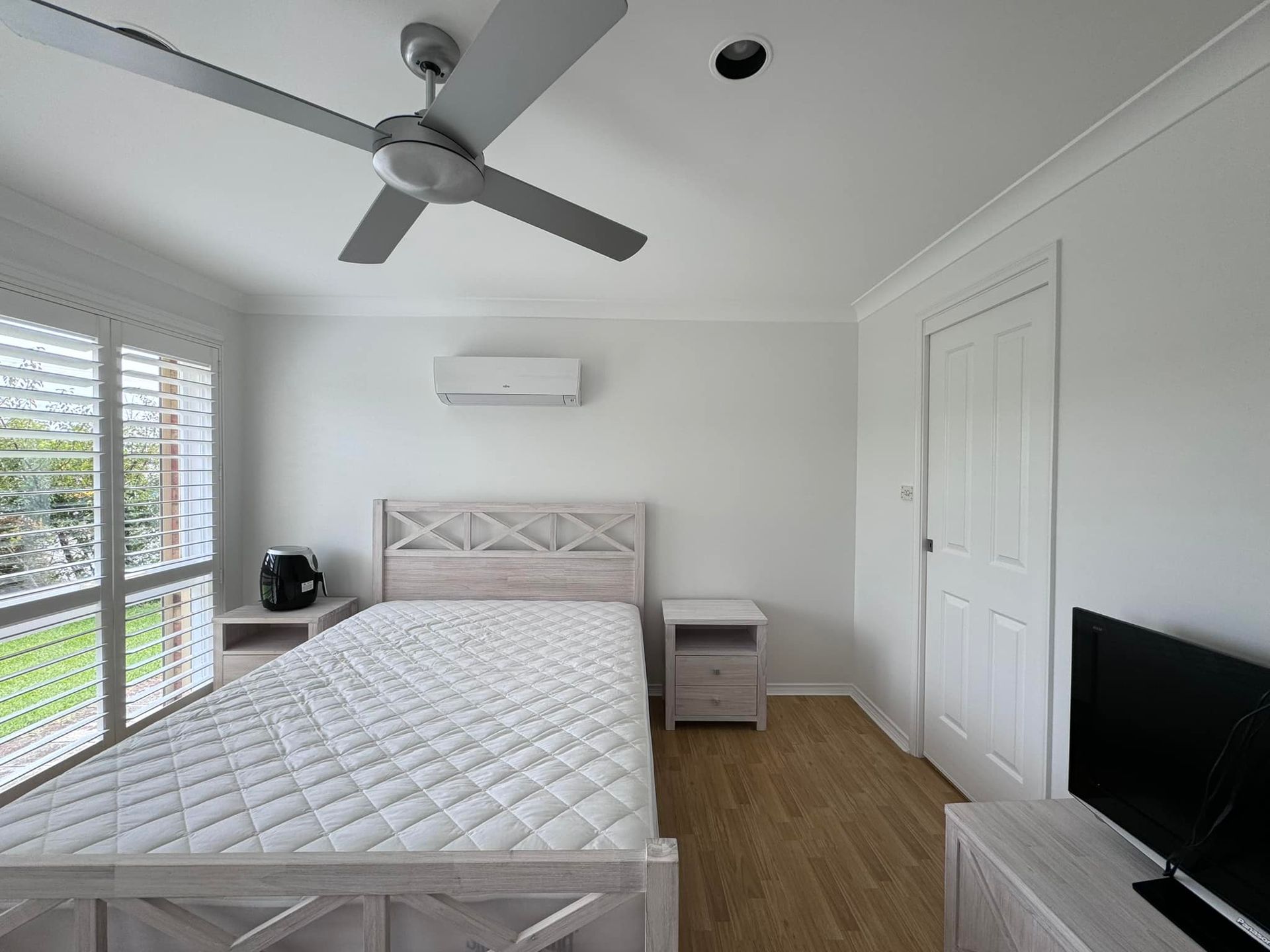A Bedroom With a Bed and a Ceiling Fan — JAX Painting Services in Central Coast, NSW