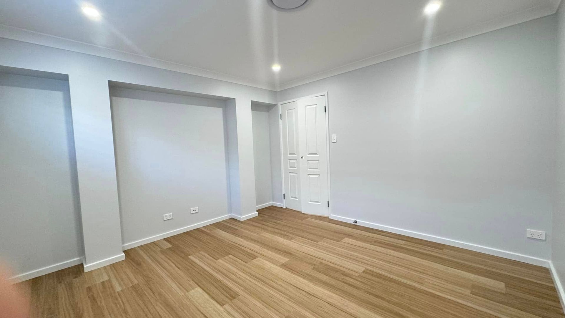 An Empty Room With Hardwood Floors and White Walls — JAX Painting Services in Central Coast, NSW