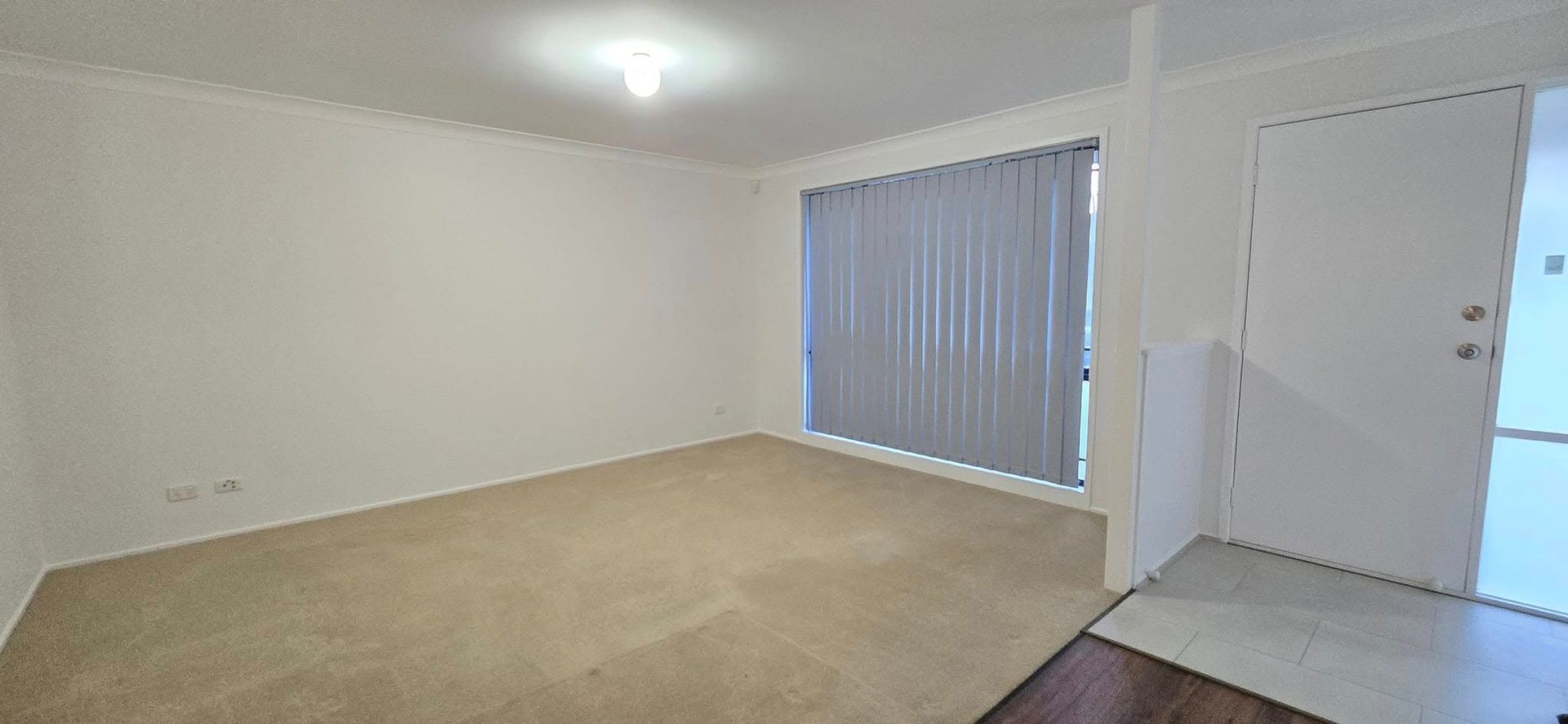 An Empty Living Room With a Large Window and a Door — JAX Painting Services in Central Coast, NSW