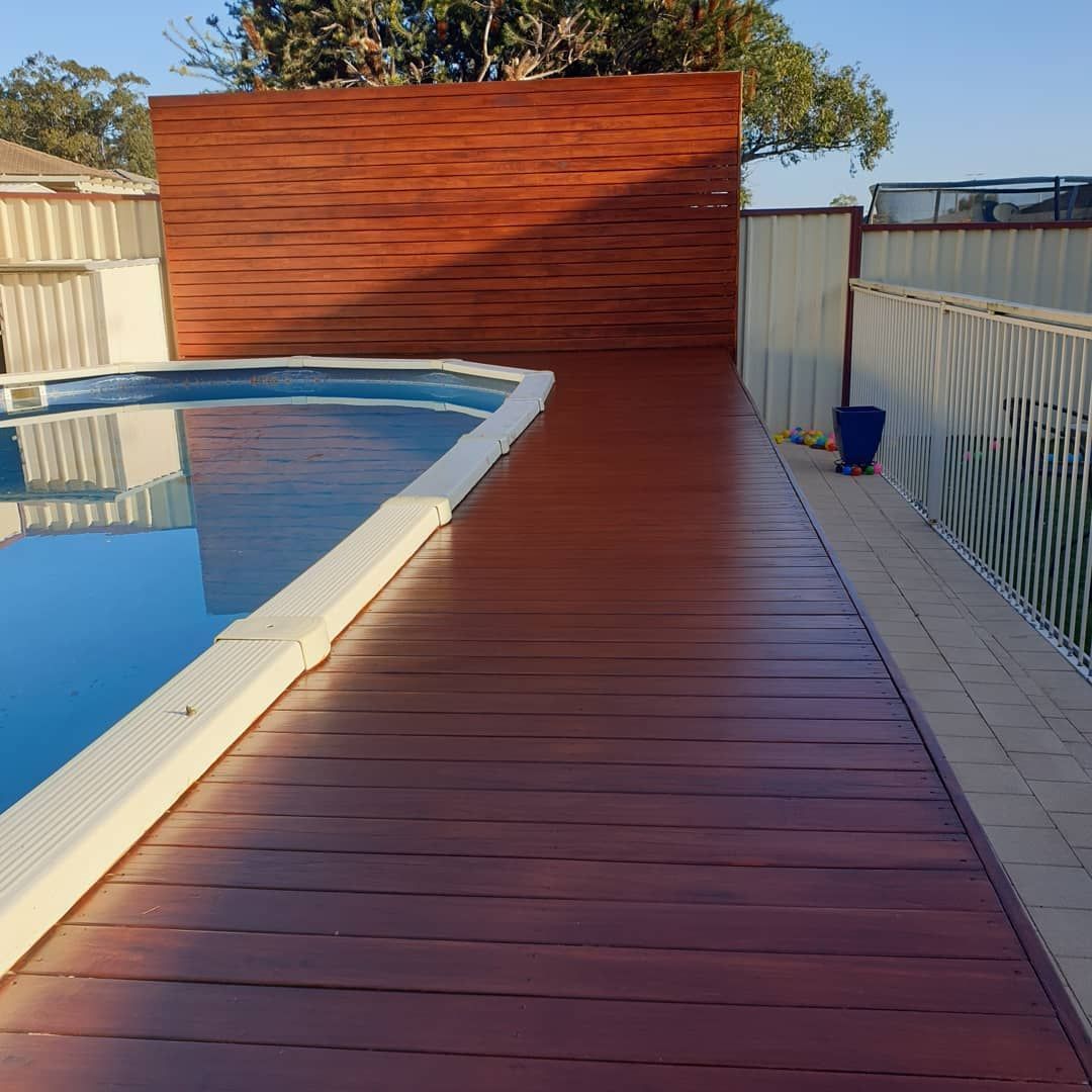 A Swimming Pool With a Wooden Walkway Leading to It — JAX Painting Services in Central Coast, NSW