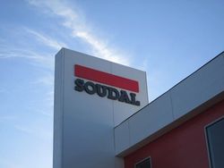 Soudal logo on a white building against a blue sky. Soudal logo on a white building against a blue sky.