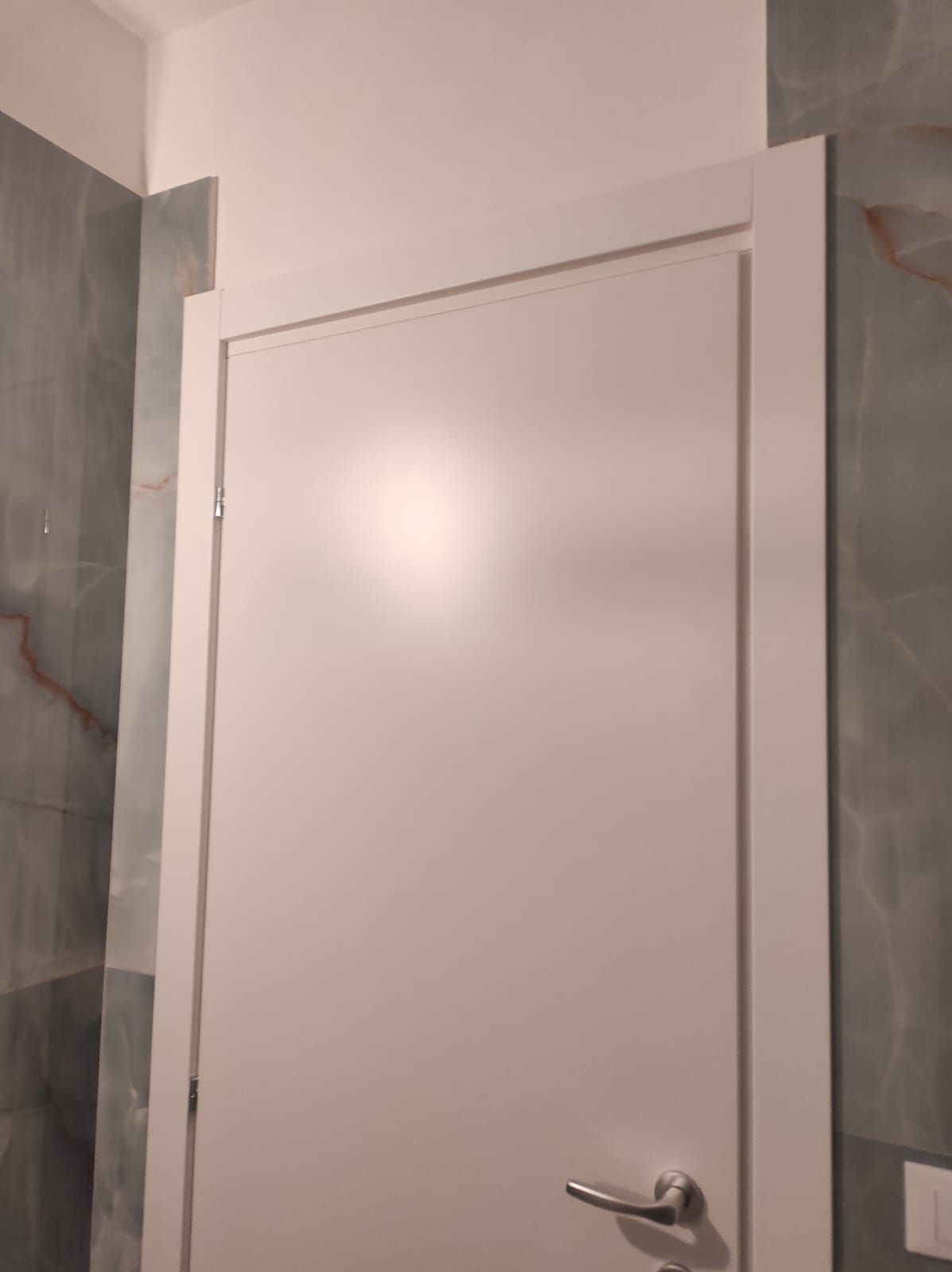 Un primo piano di una porta bianca in un bagno.