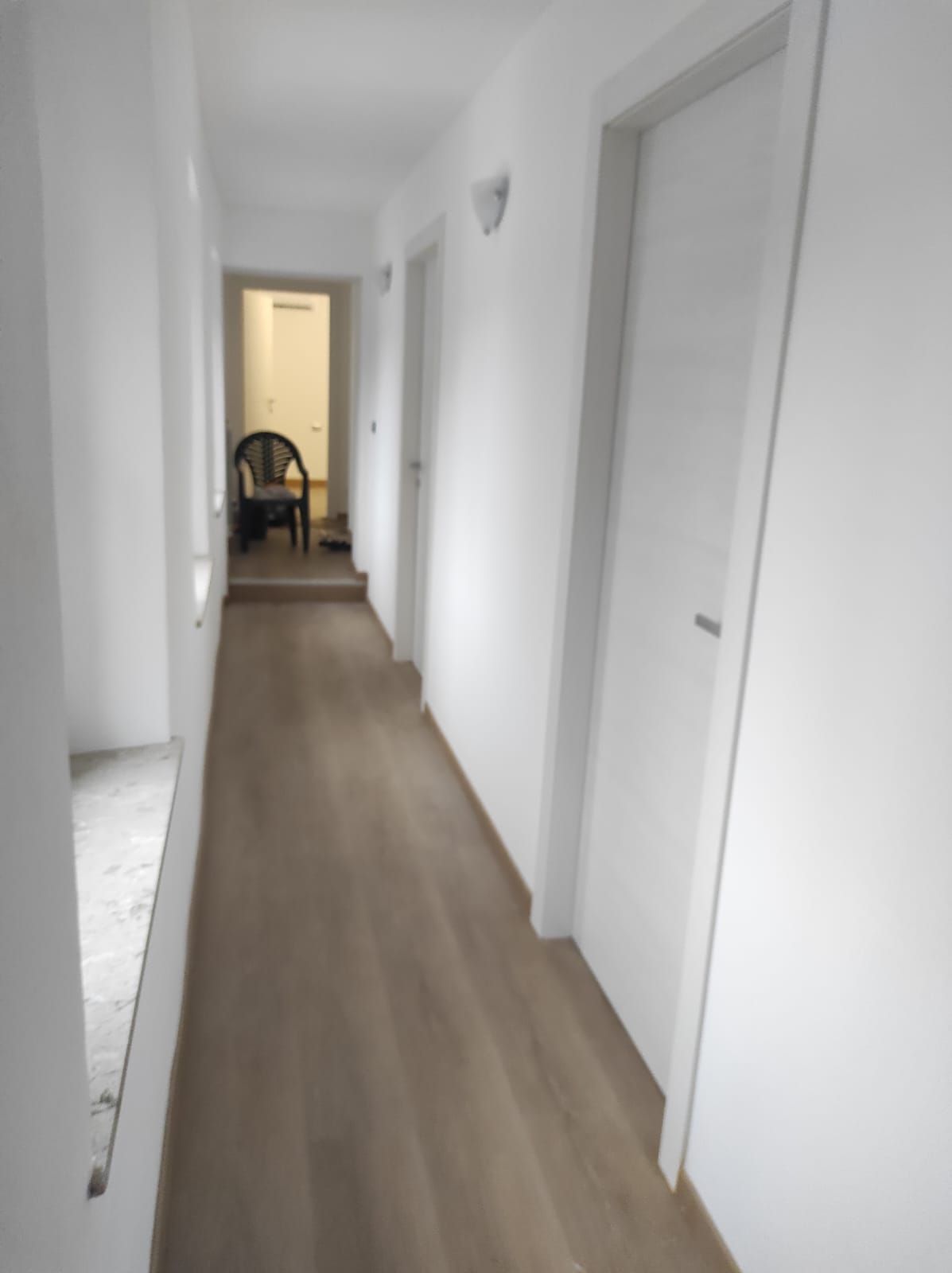 Un lungo corridoio con una sedia nell'angolo