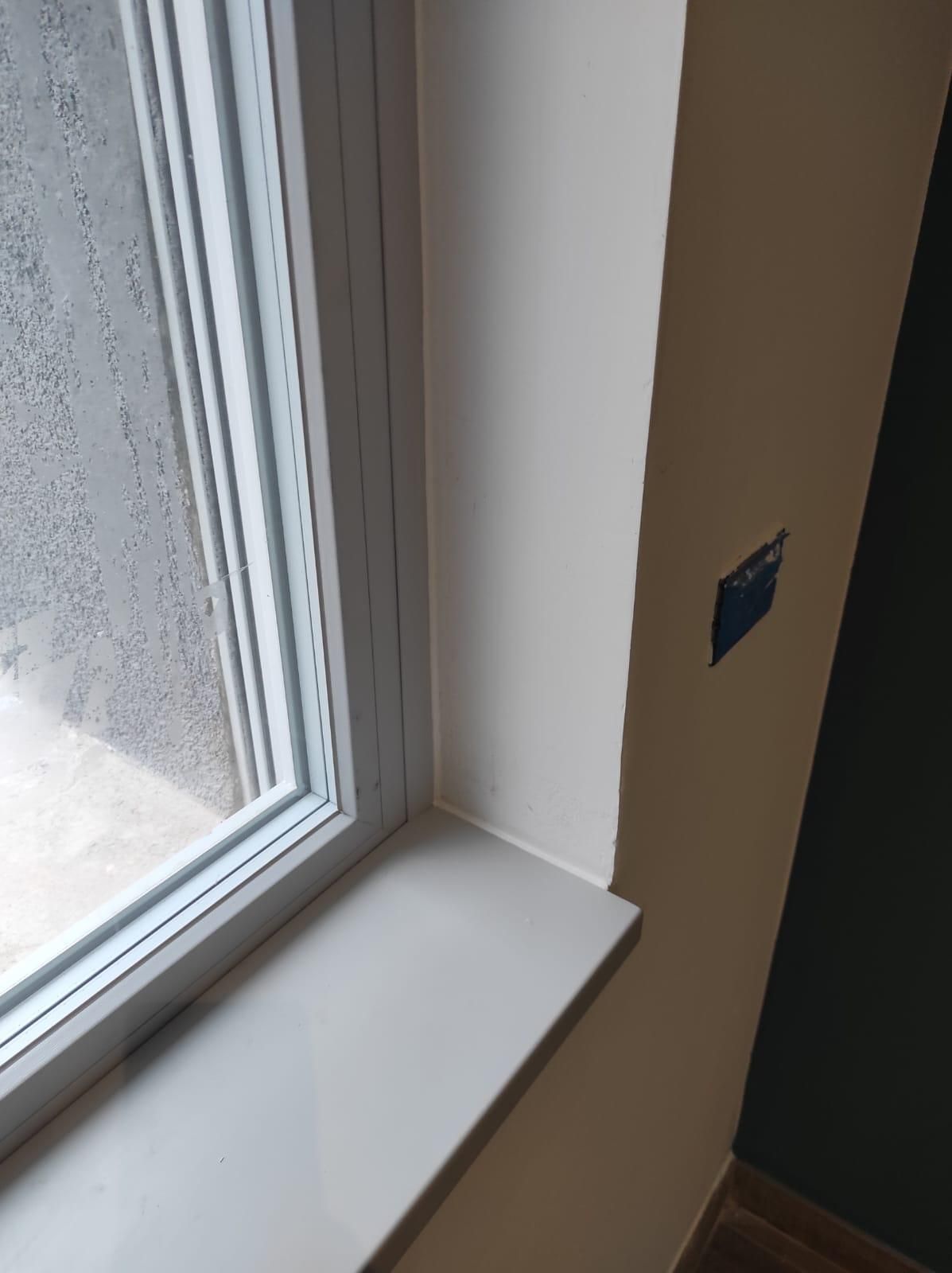 Un primo piano di una finestra con una cornice bianca in una stanza.