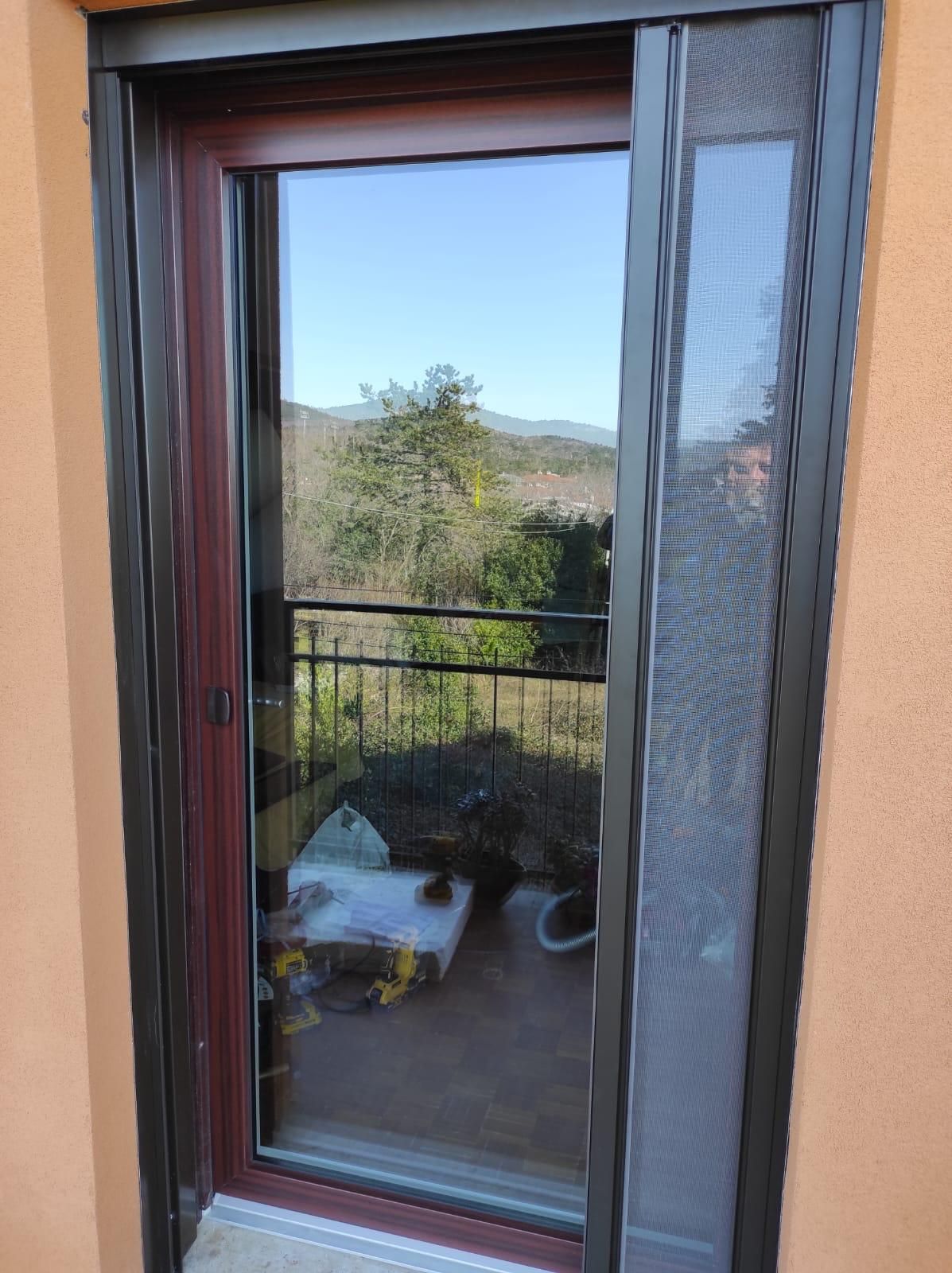 Una porta scorrevole in vetro con una zanzariera