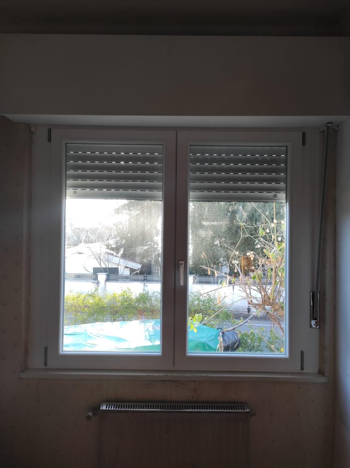 Una finestra con le persiane in una stanza con un termosifone.