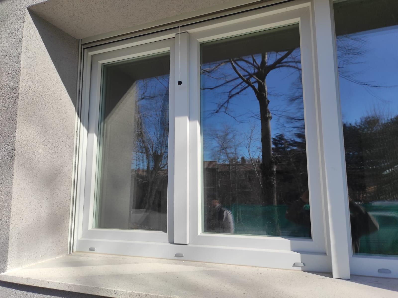 Una finestra bianca con un riflesso di alberi al suo interno