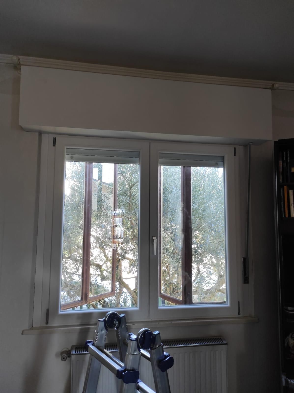 Una scala è appoggiata davanti a una finestra in una stanza.