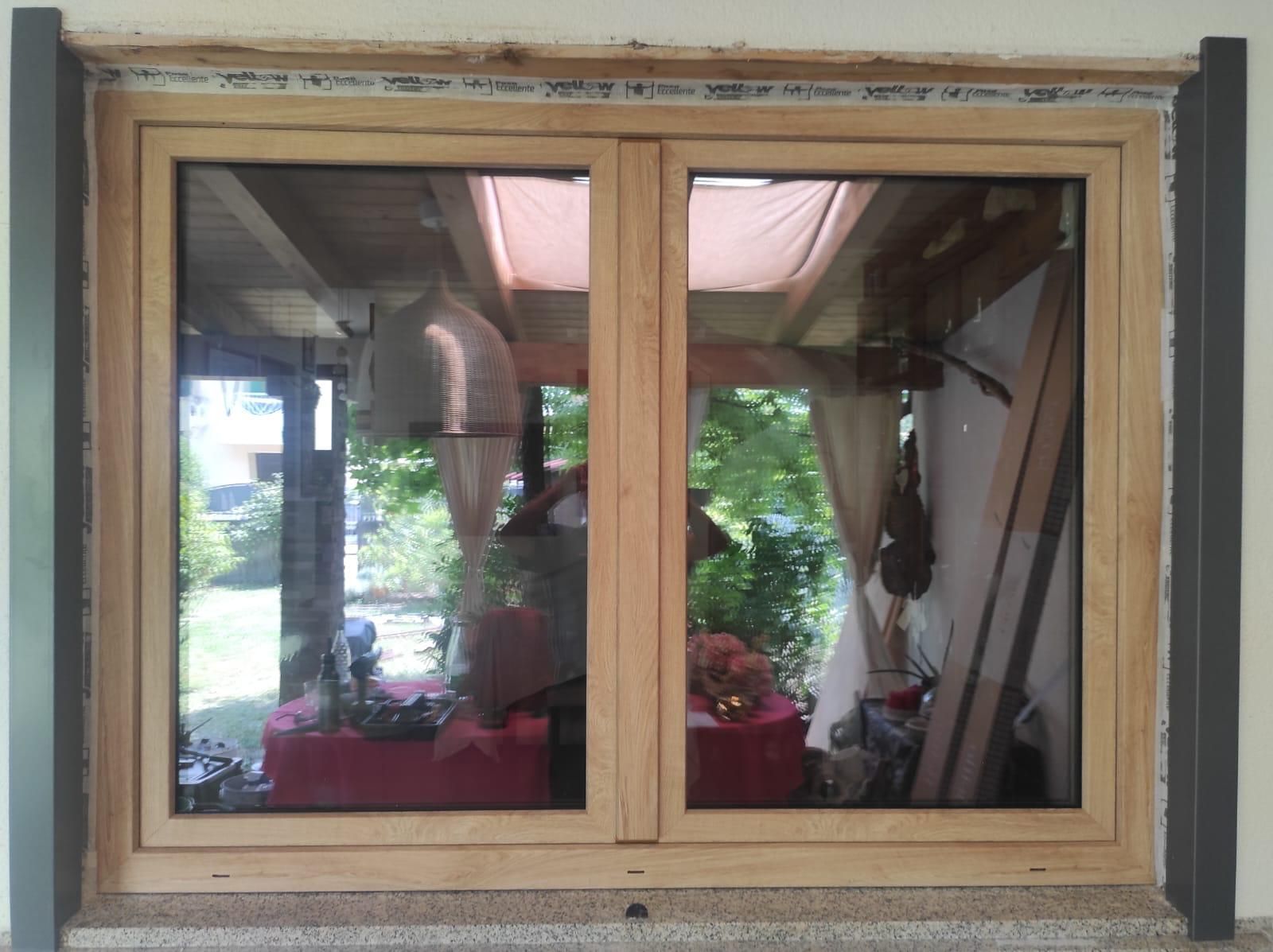 Una finestra di legno con il riflesso di un tavolo al suo interno