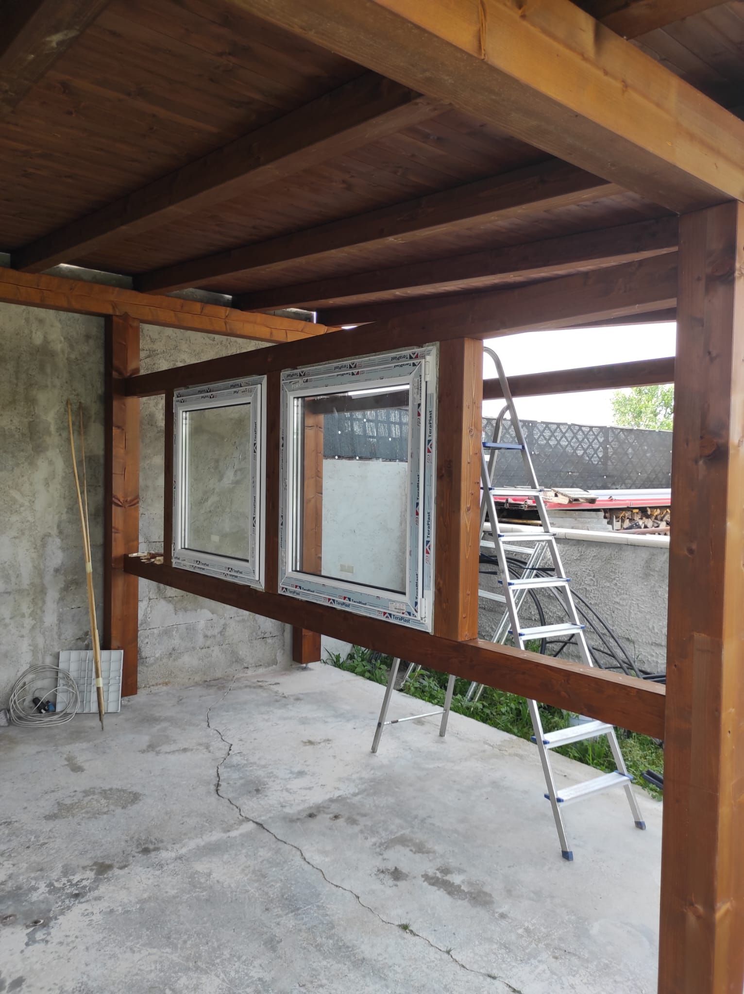 Una struttura in legno con una scala sullo sfondo.