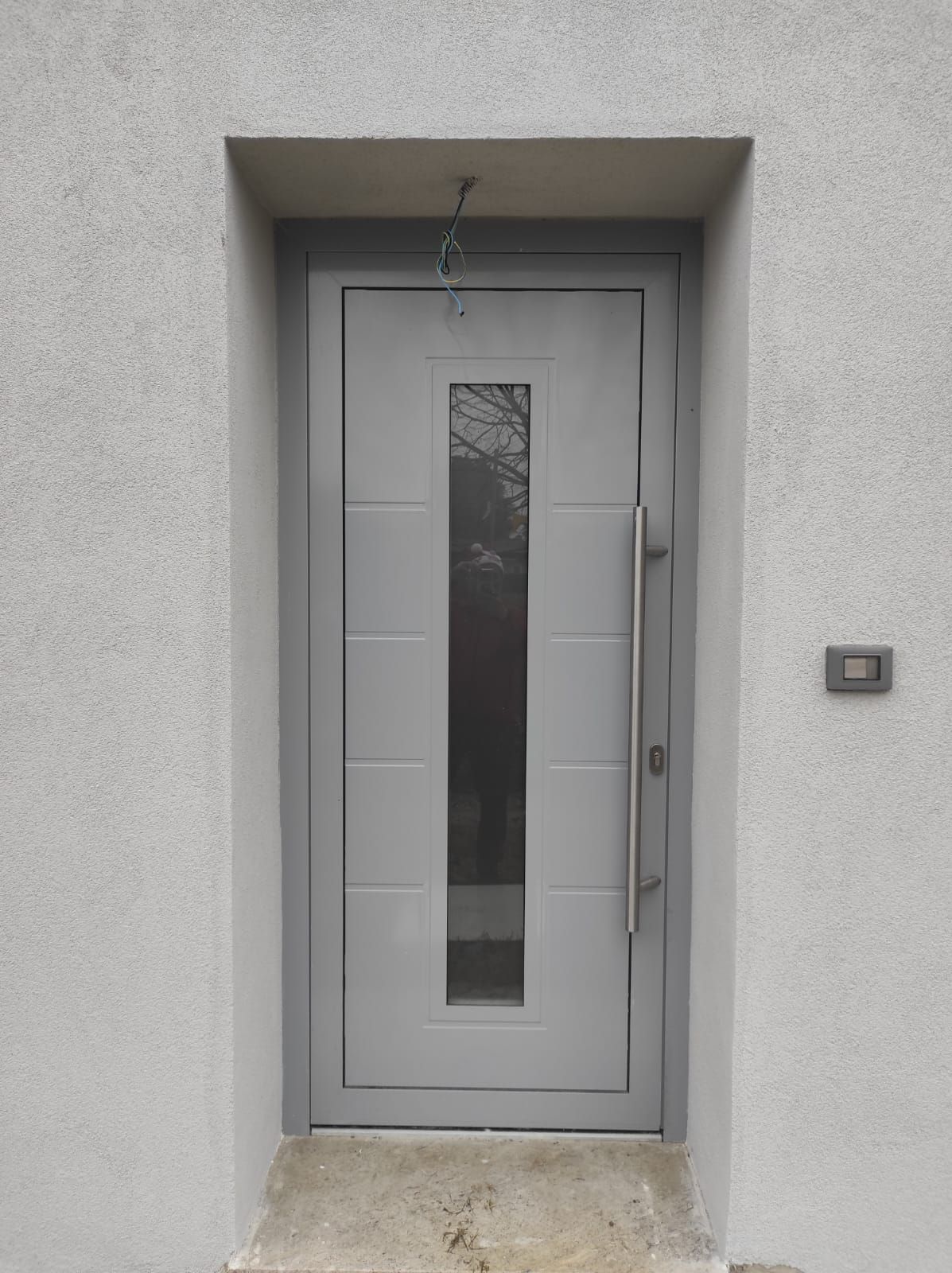 Una porta bianca con una piccola finestra sul lato