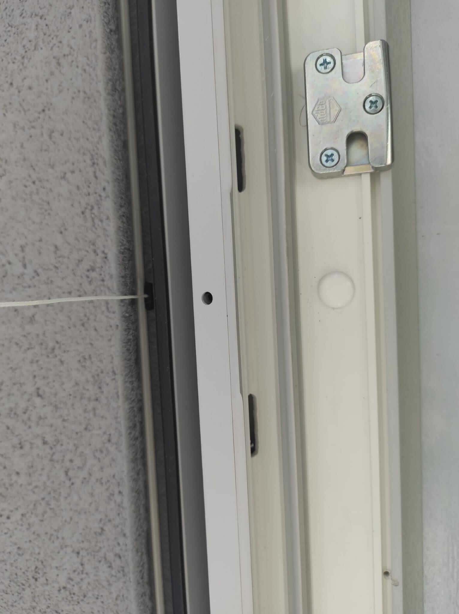 Primo piano di una porta con un chiavistello metallico.