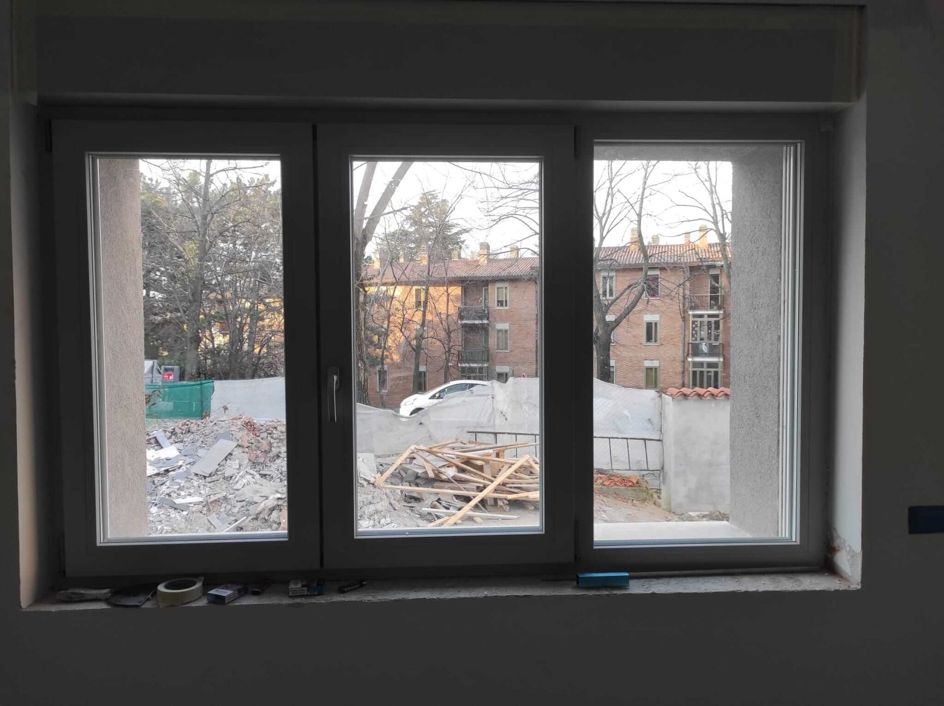 Una finestra con vista su un edificio e sugli alberi