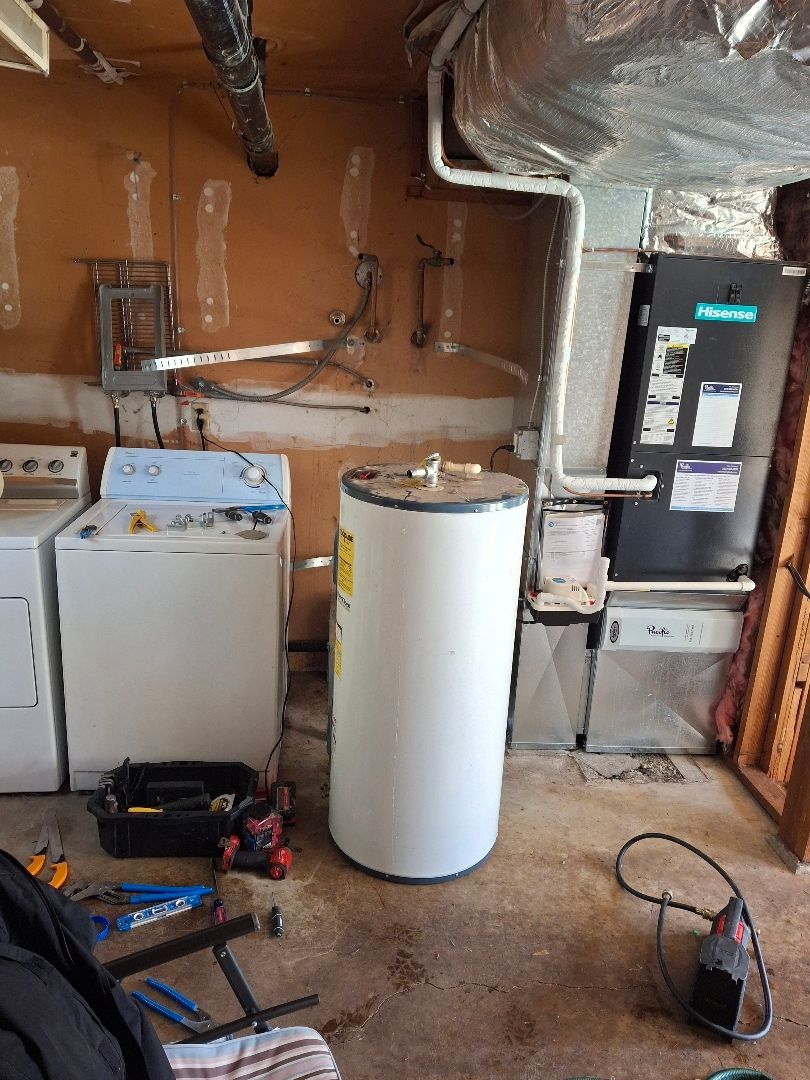 Laundry Room Featuring a washing machine, dryer, and hot water heater Installed by Royal Flush Plumbing in Tacoma