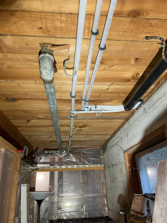 A bunch of pipes are hanging from the ceiling of a room by royal flush plumbing in tacoma