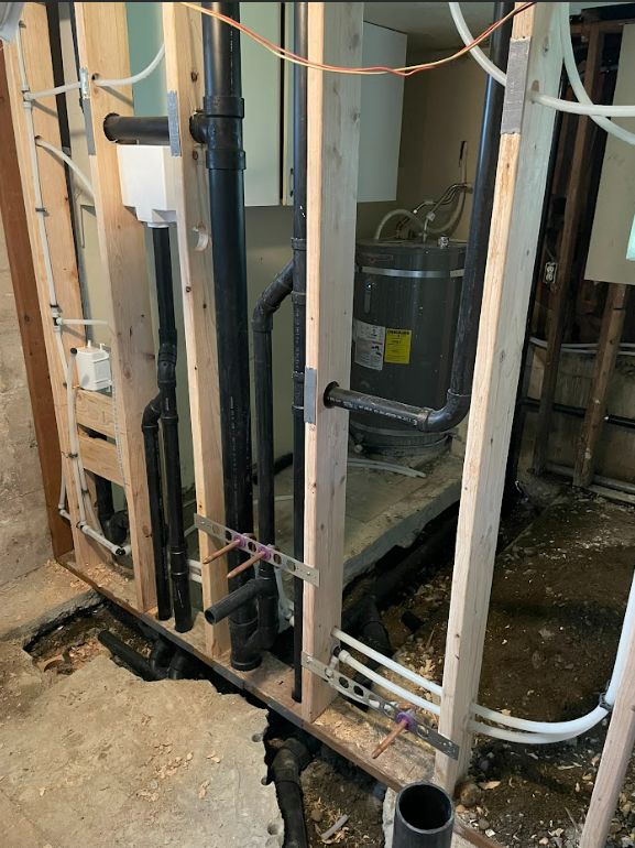 A water heater is being installed in a bathroom under construction by royal flush plumbing in tacoma.