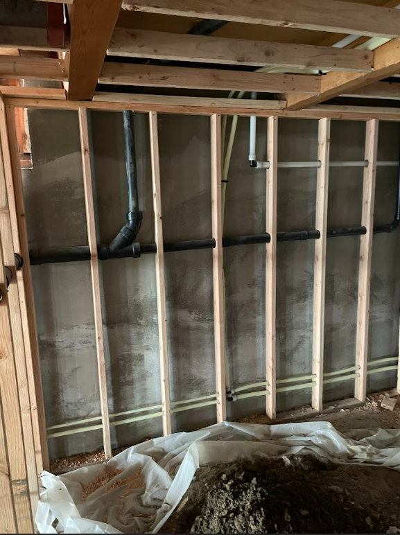 A room with wooden beams and pipes on the wall