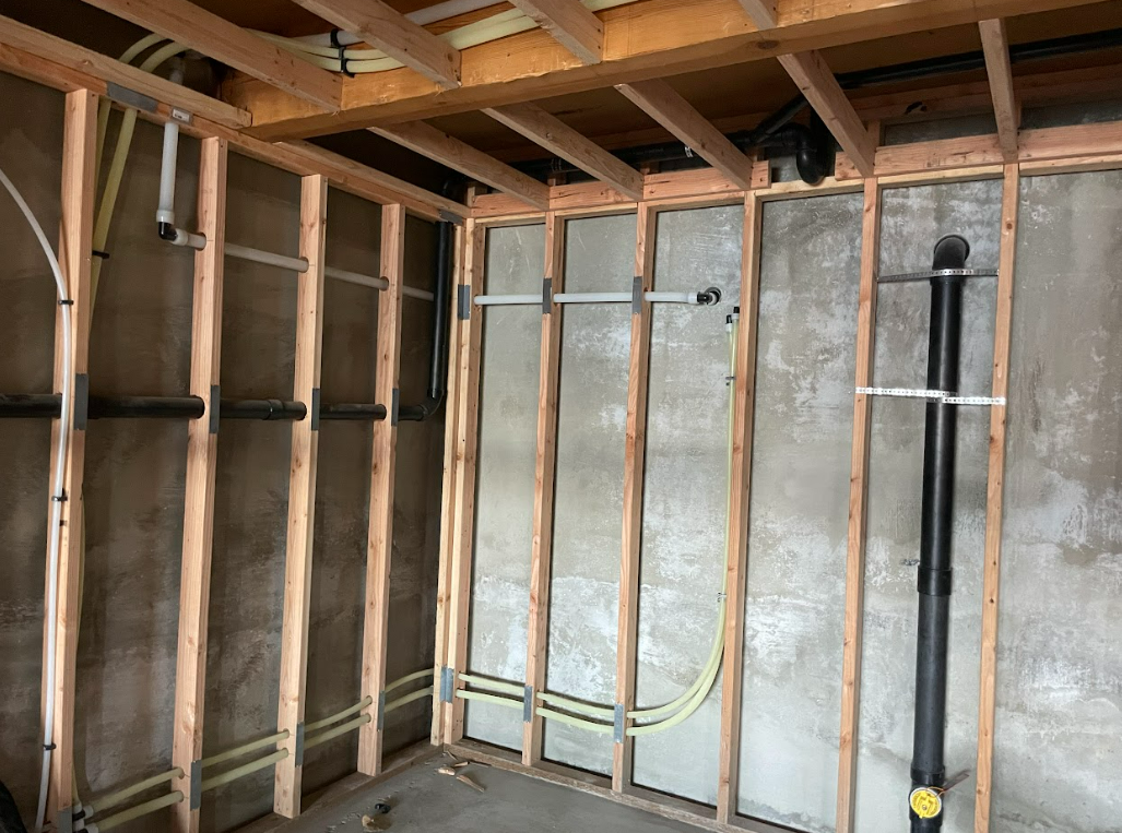 A room with wooden beams and pipes on the wall.