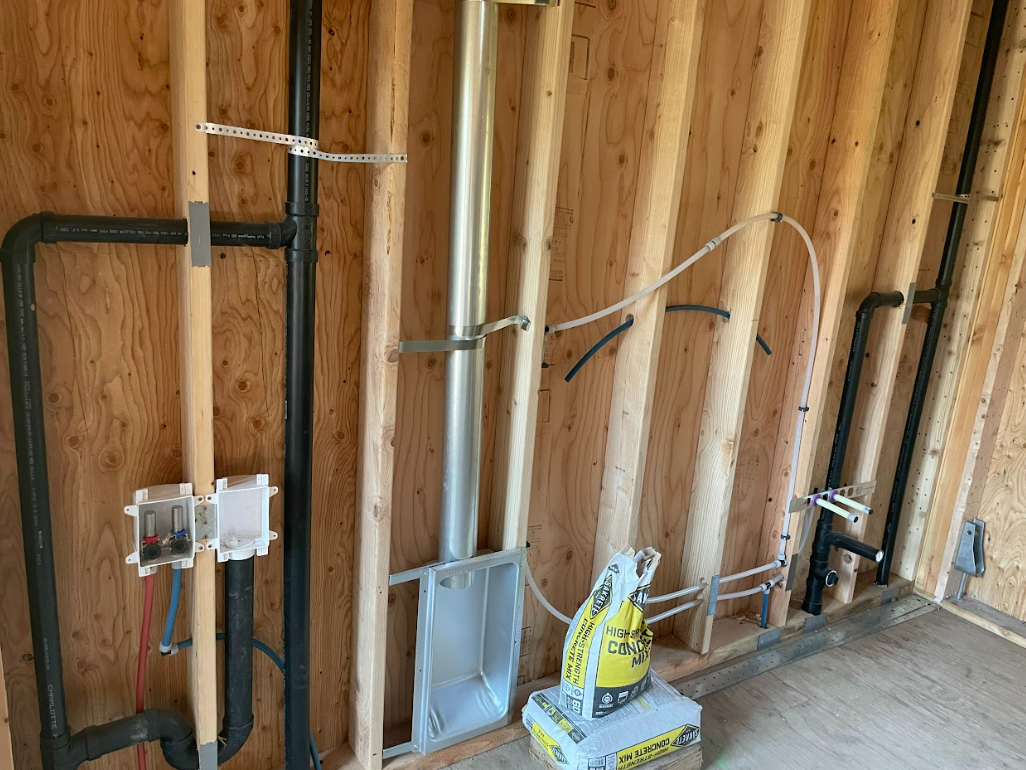 A room with a lot of pipes and wires on the wall.