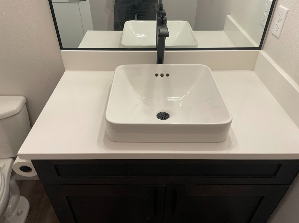 A bathroom with a sink , toilet , and mirror.