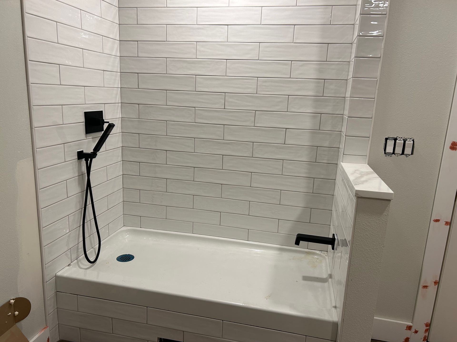 A bathroom with a bathtub with a handheld shower head installed by Royal Flush Plumbing in Tacoma