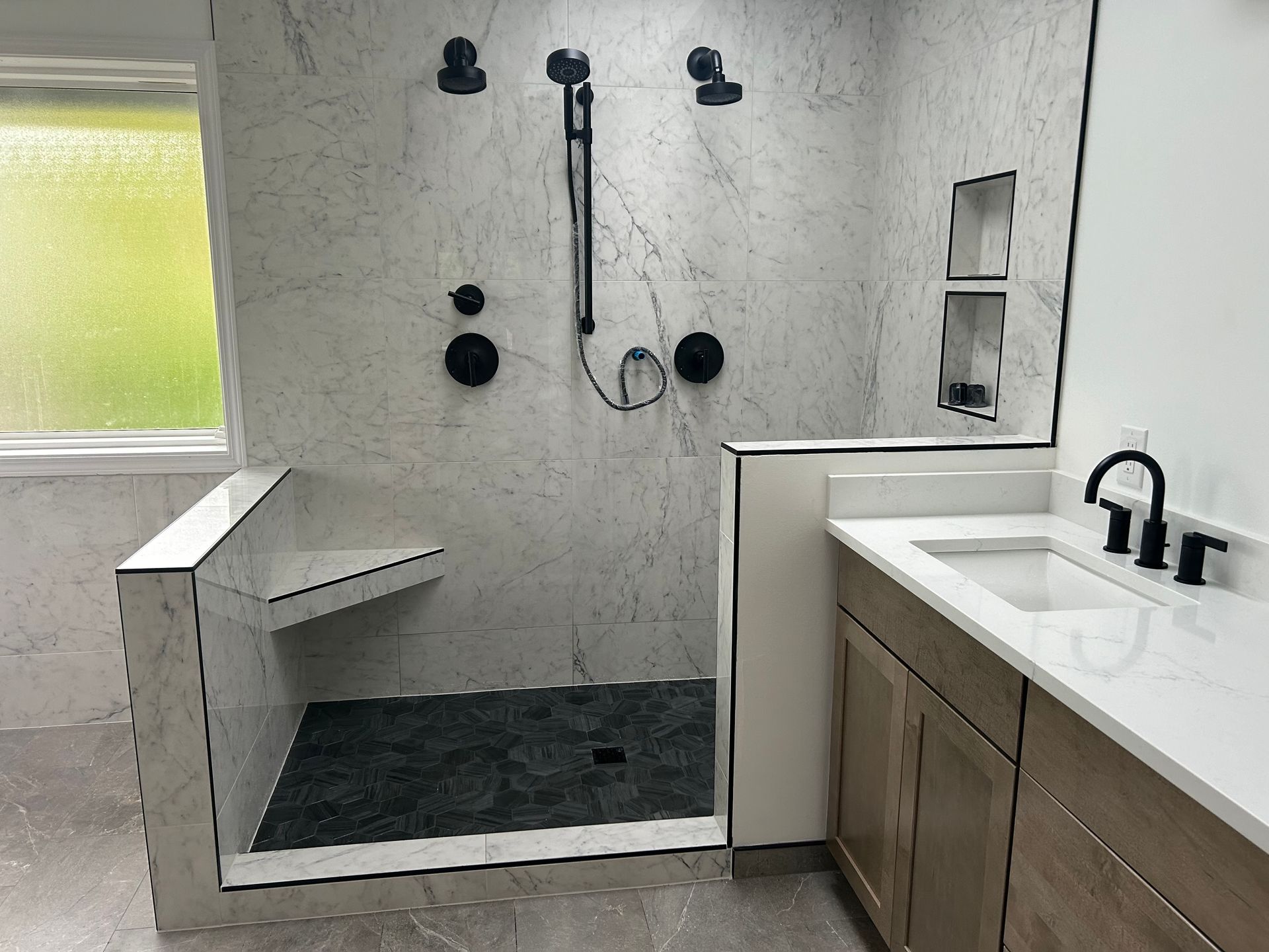 A bathroom with a walk in shower and a sink installed by Royal Flush Plumbing in Tacoma