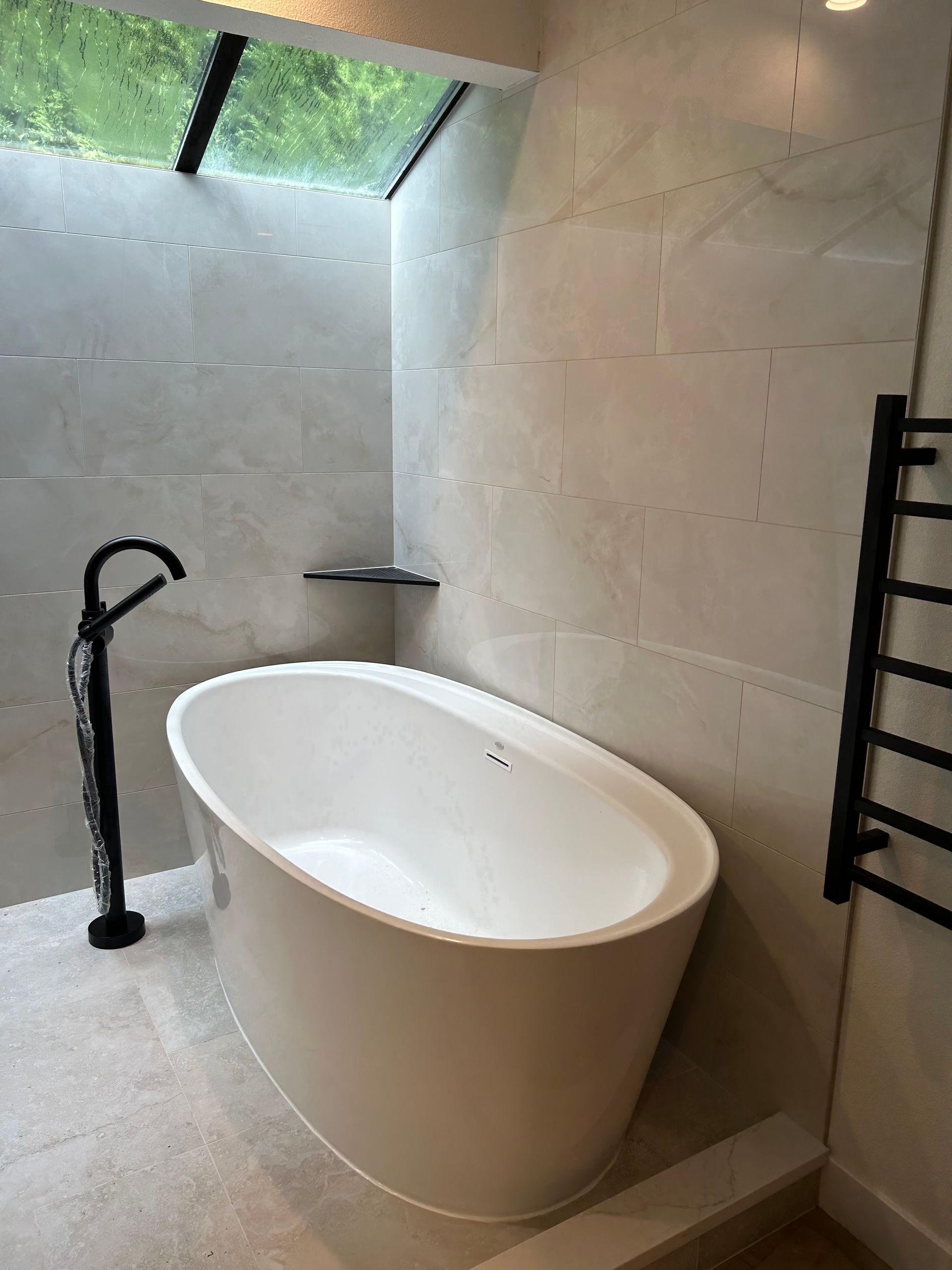 A bathroom with a bathtub and a shower installed by Royal Flush Plumbing in Tacoma