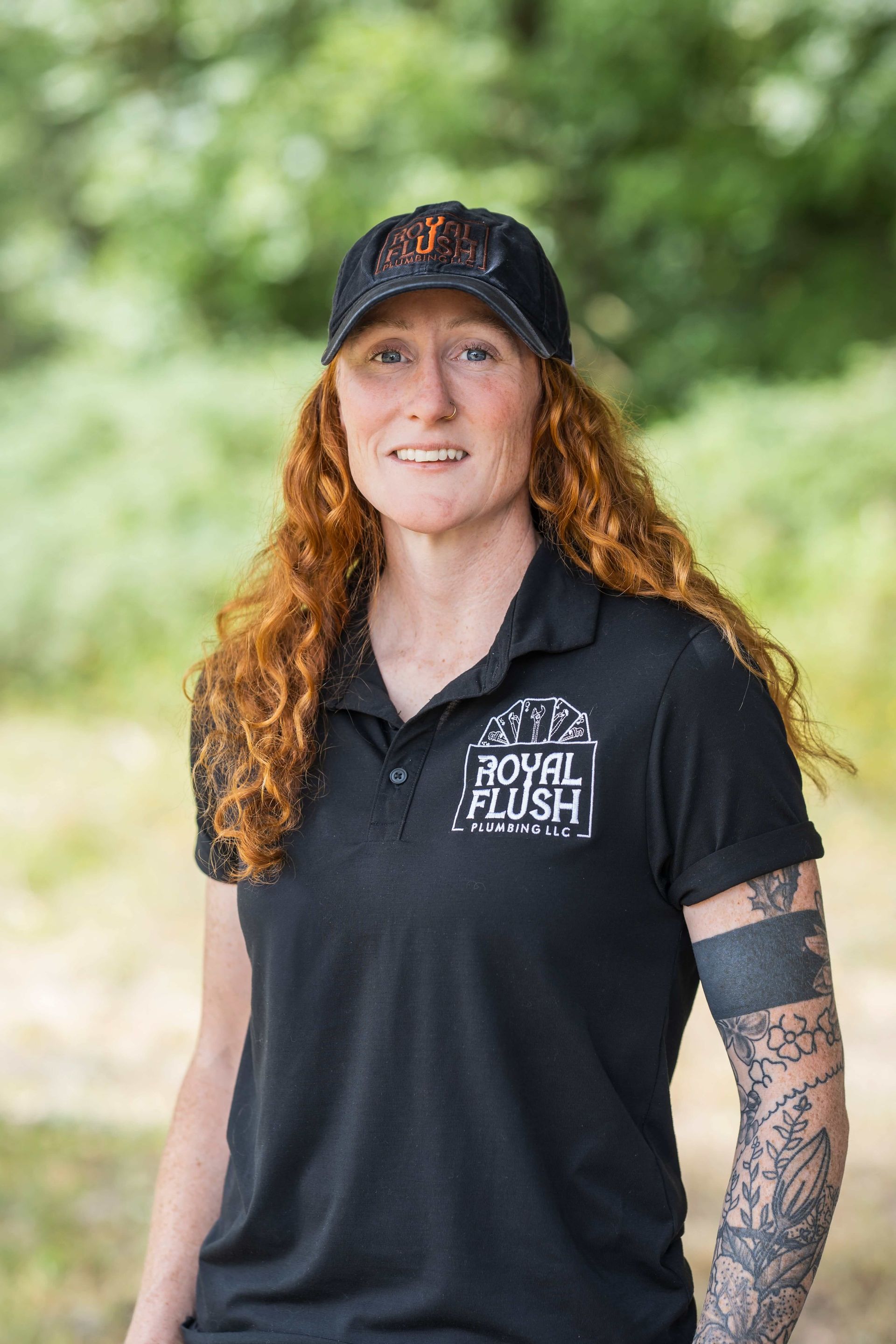 A man wearing a black jacket and a black beanie is smiling in front of a royal flush sign.