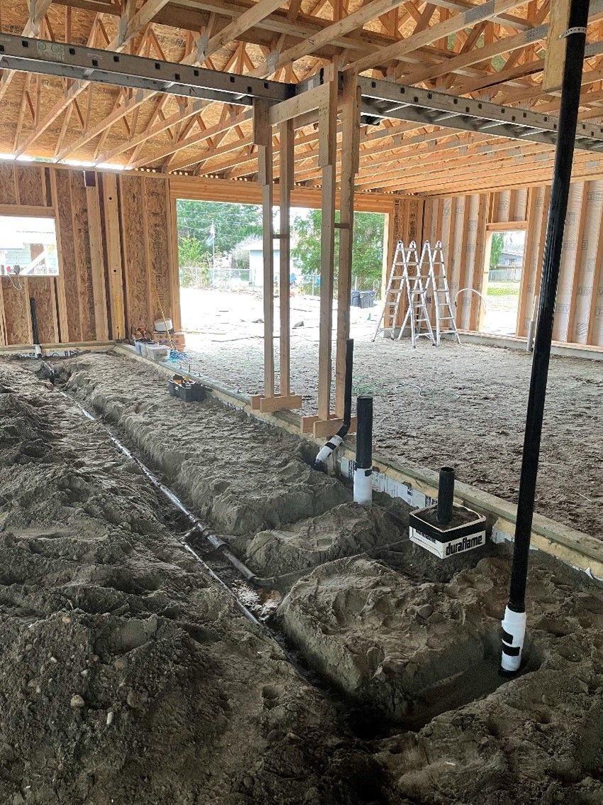 A house under construction with a lot of pipes in the dirt by royal flush plumbing in tacoma.