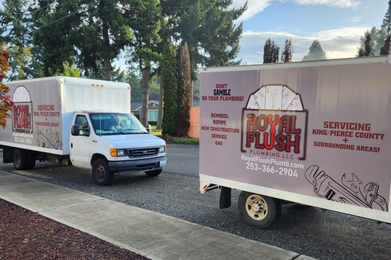 Two parked Royal Flush Plumbing branded vans