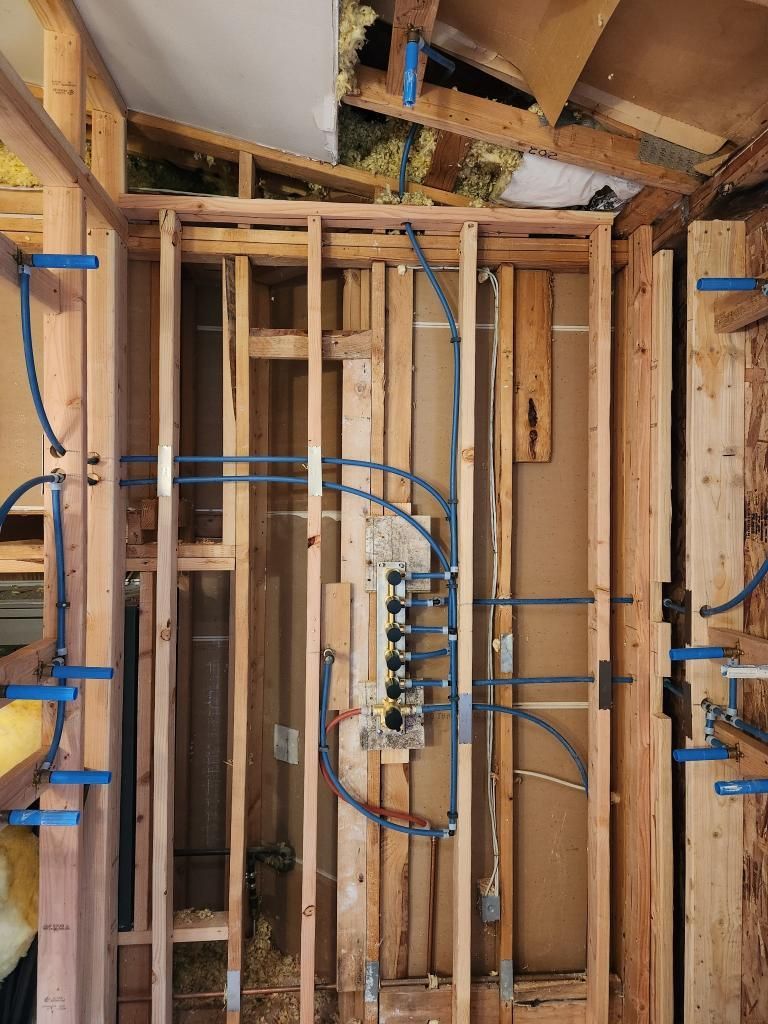 A wooden wall with a lot of wires coming out of it.