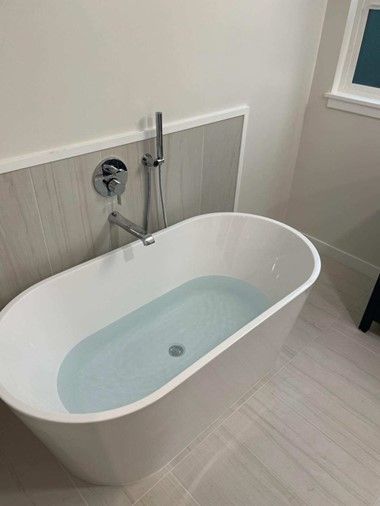 A white bathtub with blue water in a bathroom by royal flush plumbing in tacoma.