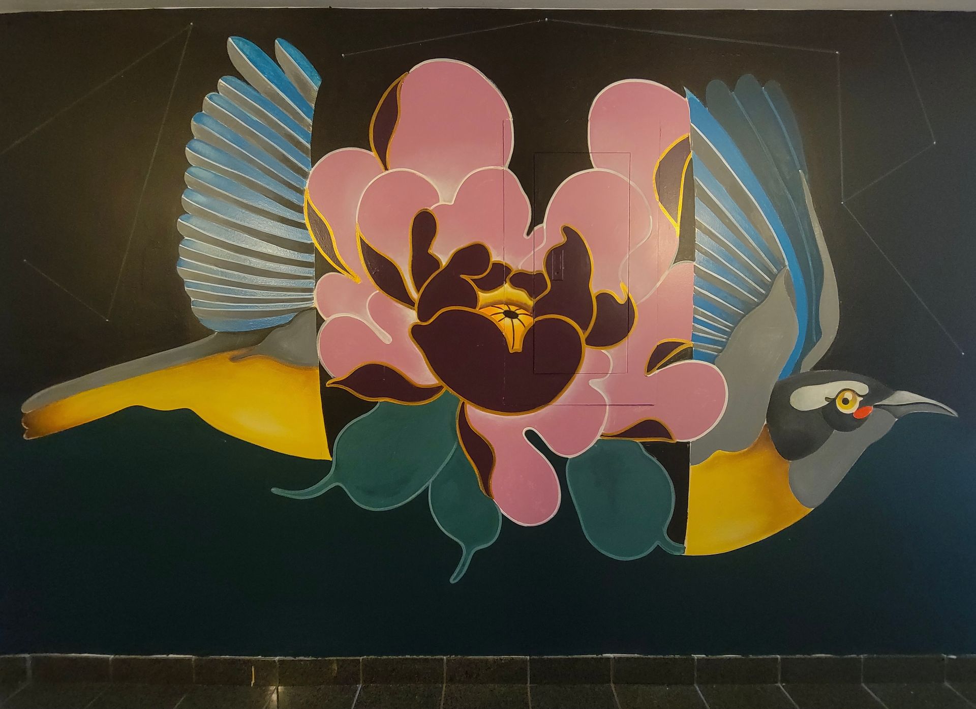 Mural of a bird opened up by the middle with a flower as it's center. 