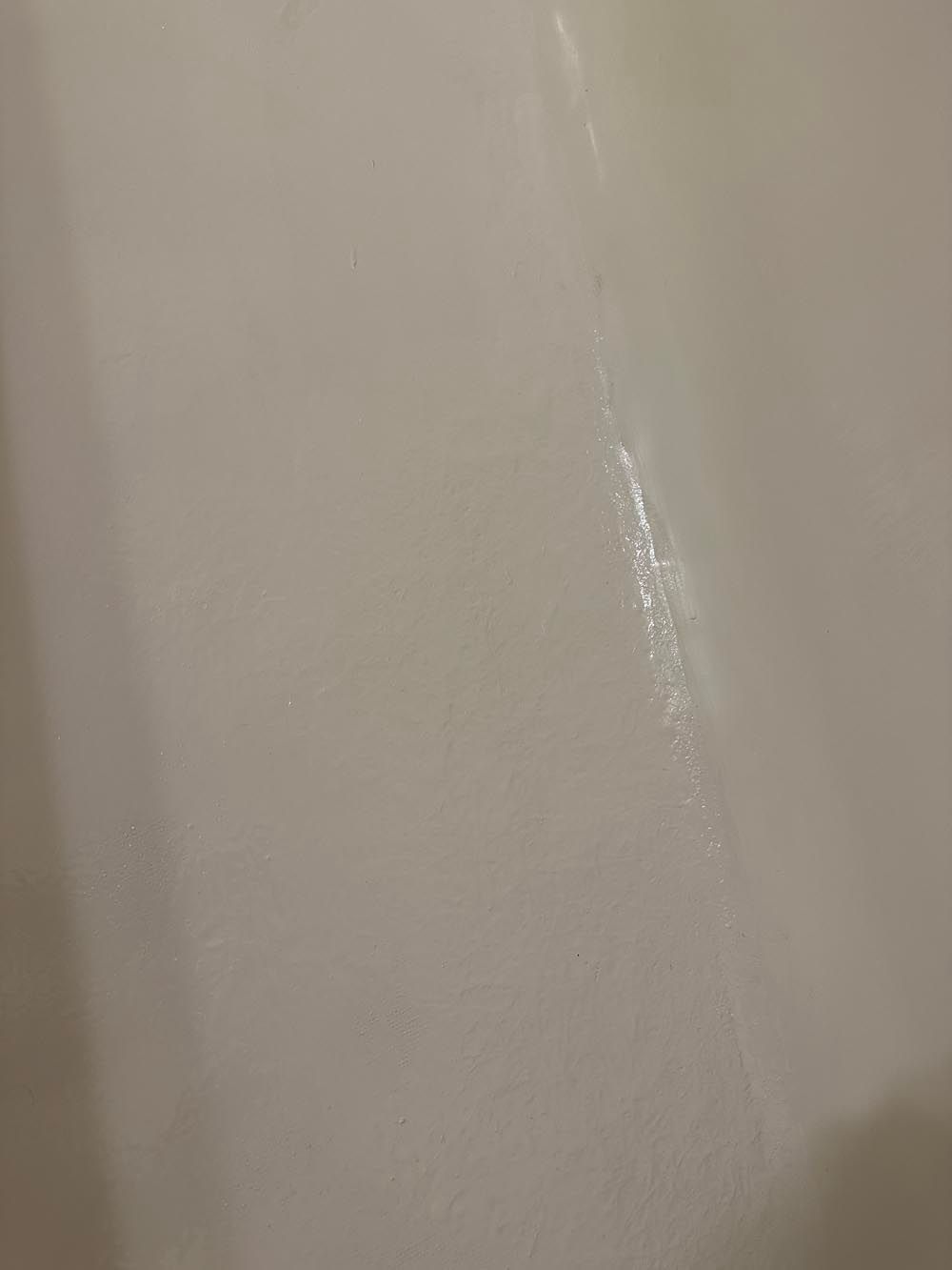Off-white wall with a vertical streak of lighter color, possibly caulk.