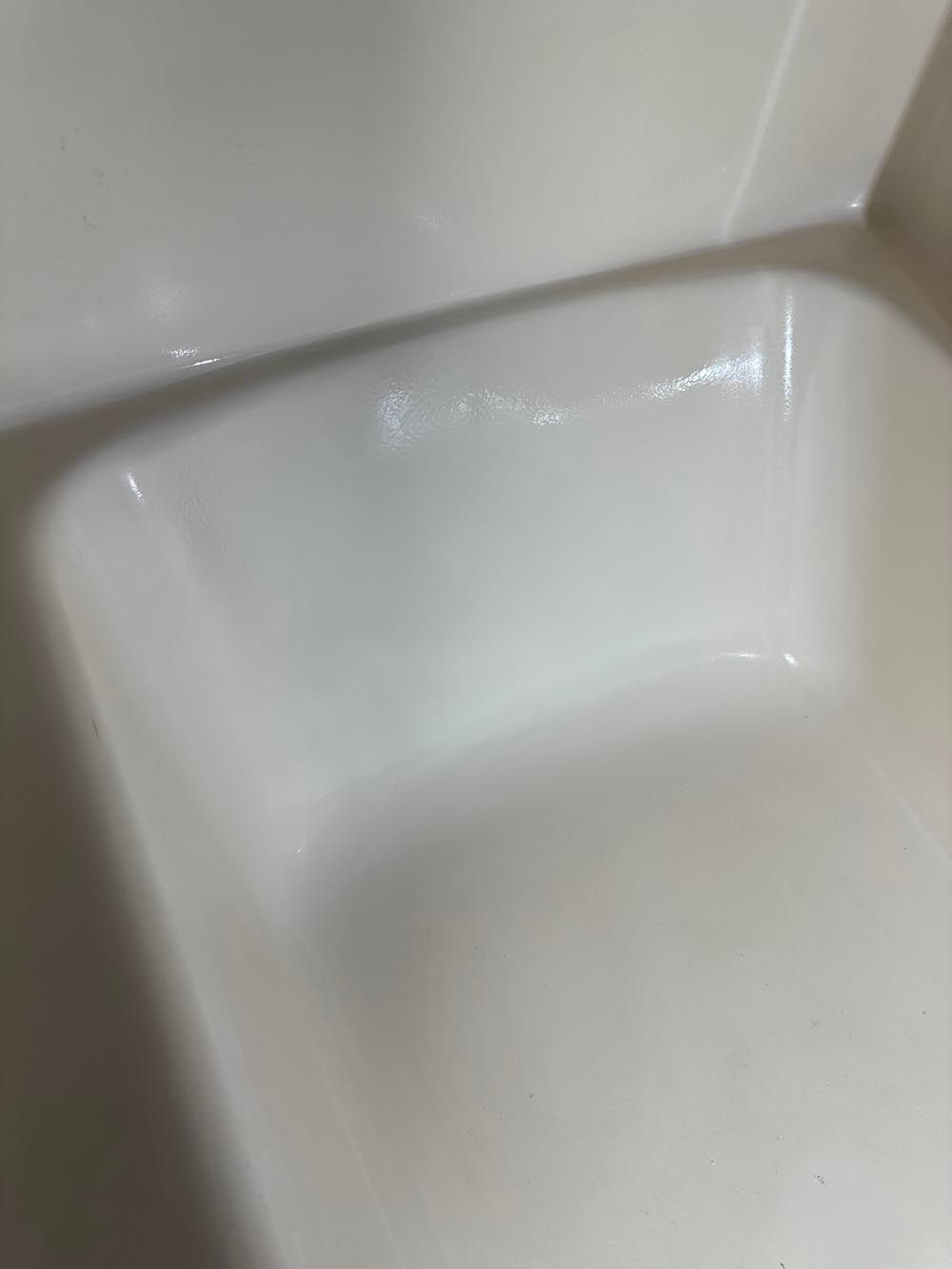 White bathtub with a built-in seat, close-up angled view.