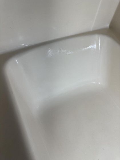 Close-up of a white bathtub with a crack along the top edge.